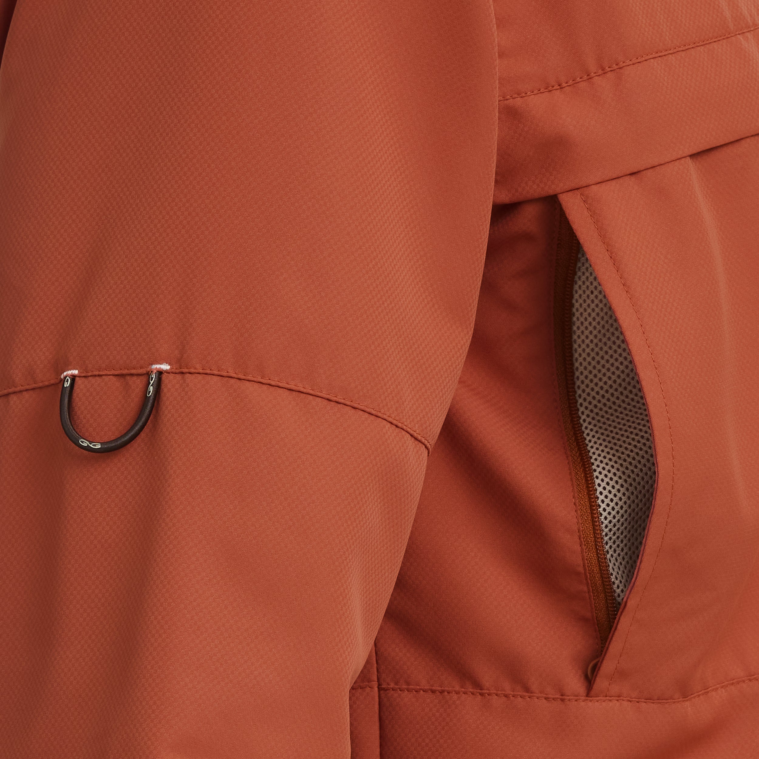 Close-up of a brown jacket with a zipper and mesh material.