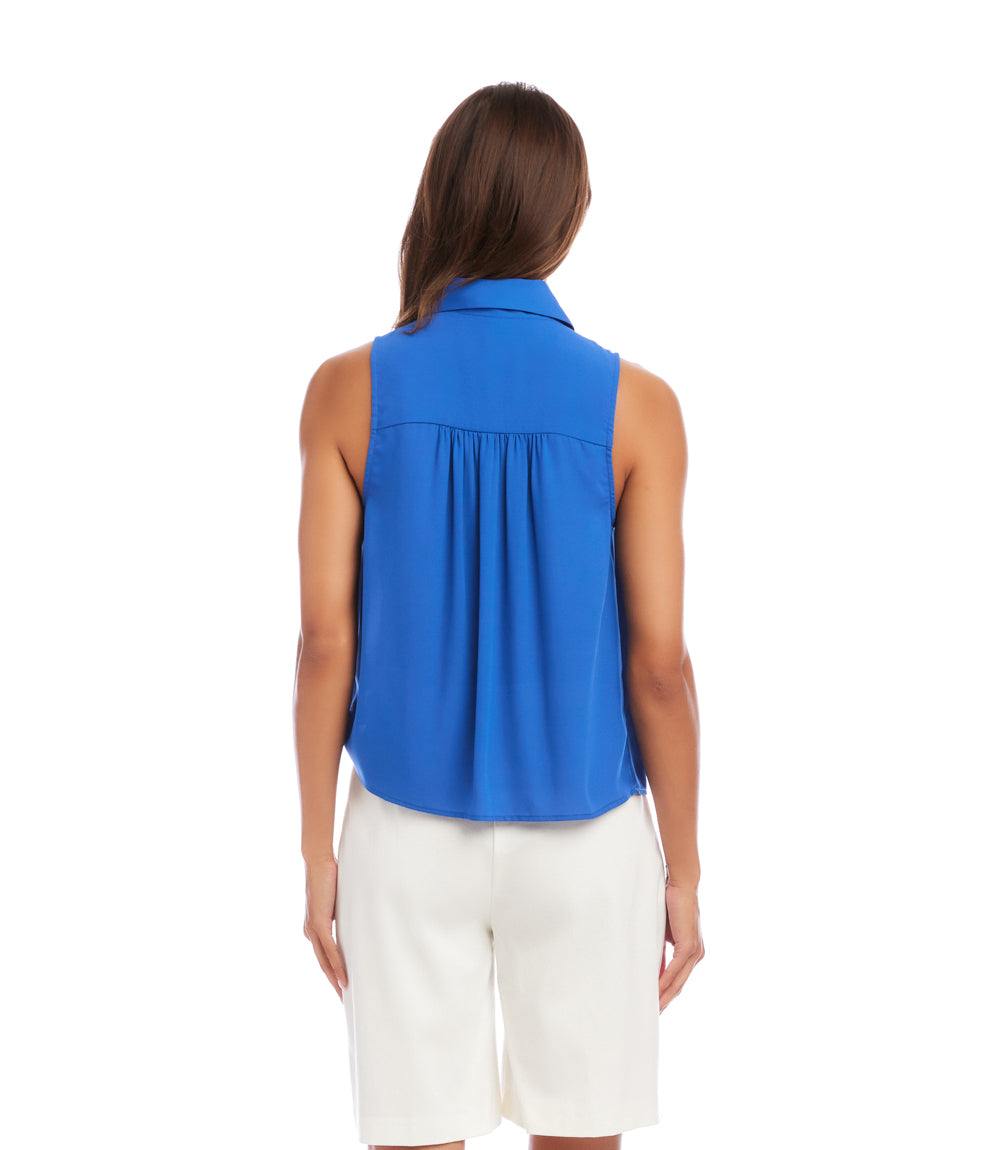 Woman wearing a blue sleeveless top and white shorts on a white background