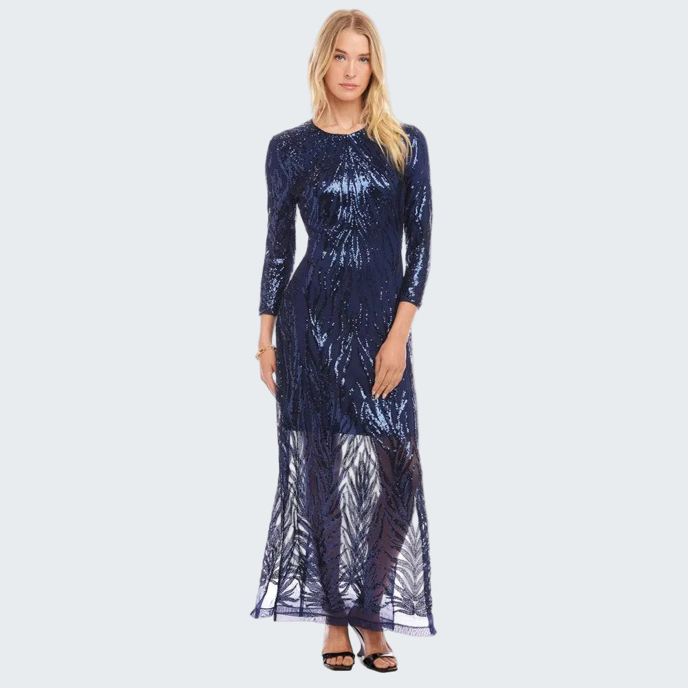 Woman wearing a long, dark blue dress with a sheer overlay on a white background
