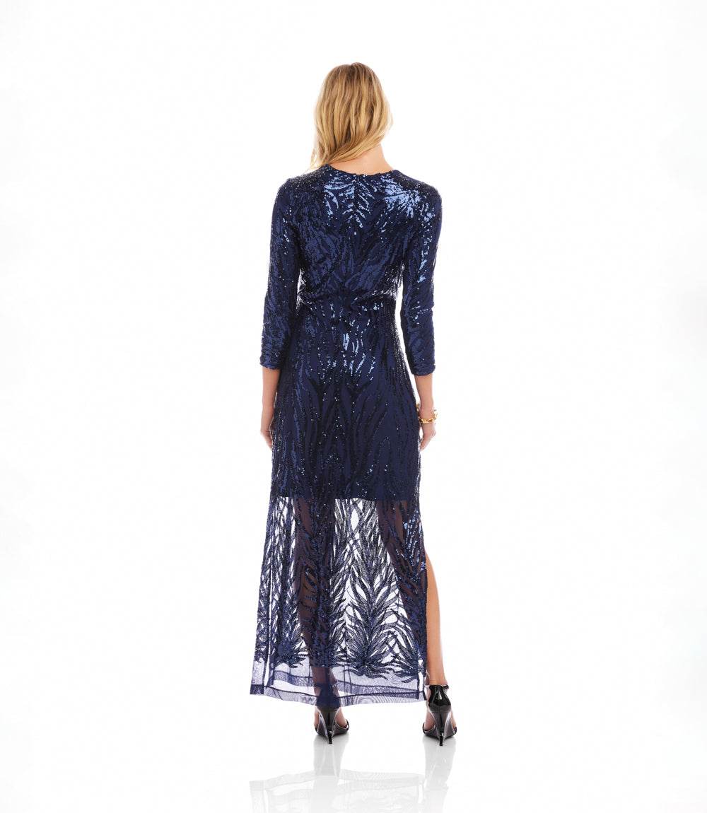 Woman wearing a long, dark blue dress with a pattern on a white background