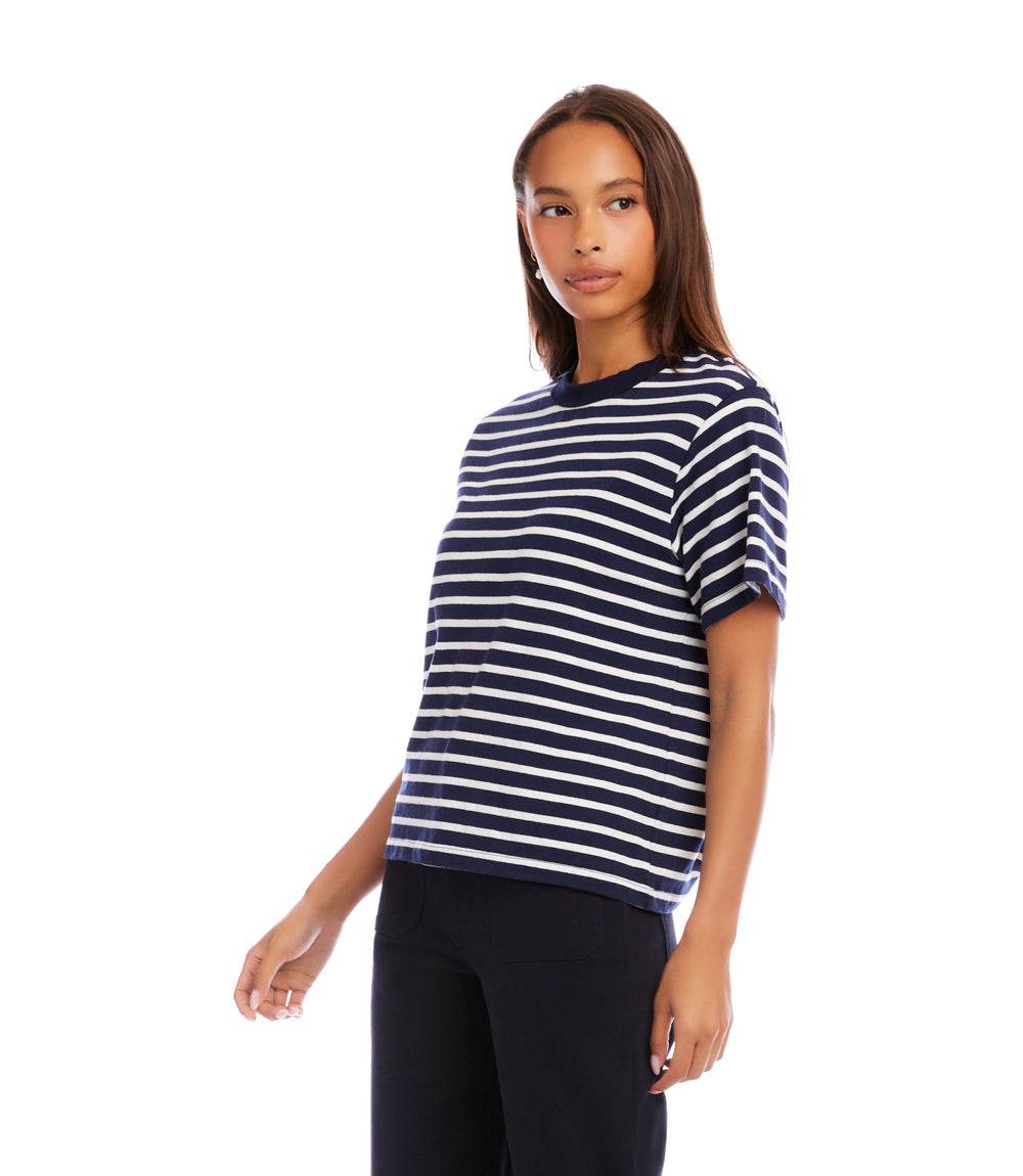 Woman wearing a navy and white striped shirt on a white background