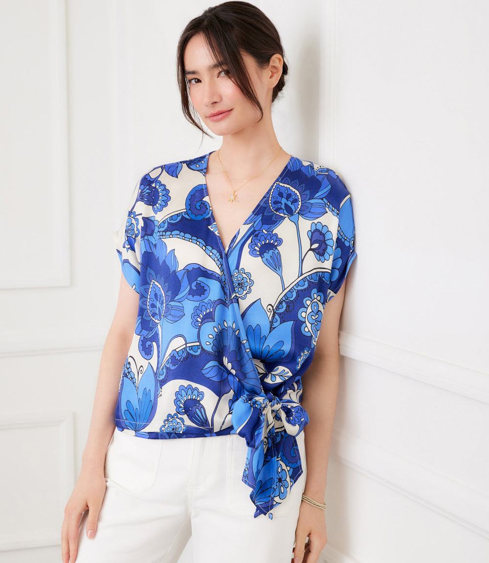 Woman wearing a blue and white patterned top against a white background