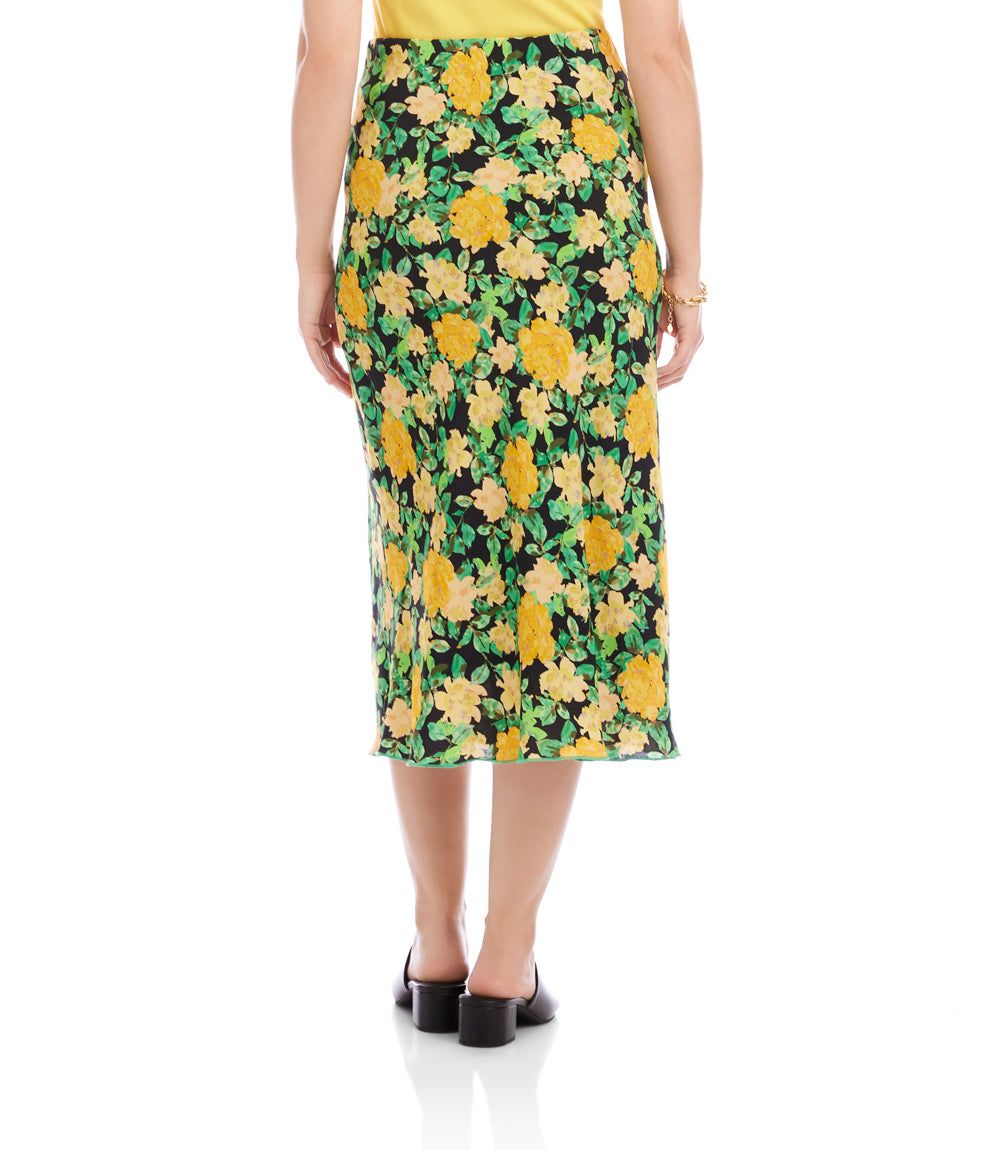 Person wearing a floral skirt with yellow flowers on a green background