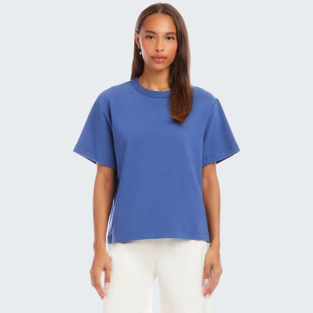 Woman wearing a blue t-shirt and white shorts on a white background