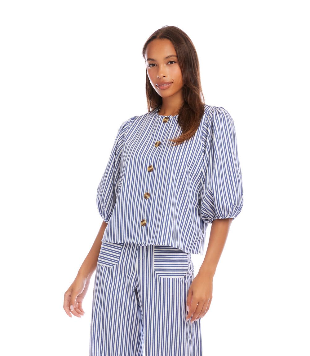 Woman wearing a blue and white striped outfit with gold buttons on a white background