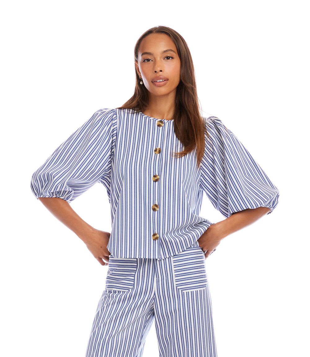 Woman wearing a blue and white striped outfit with puff sleeves on a white background