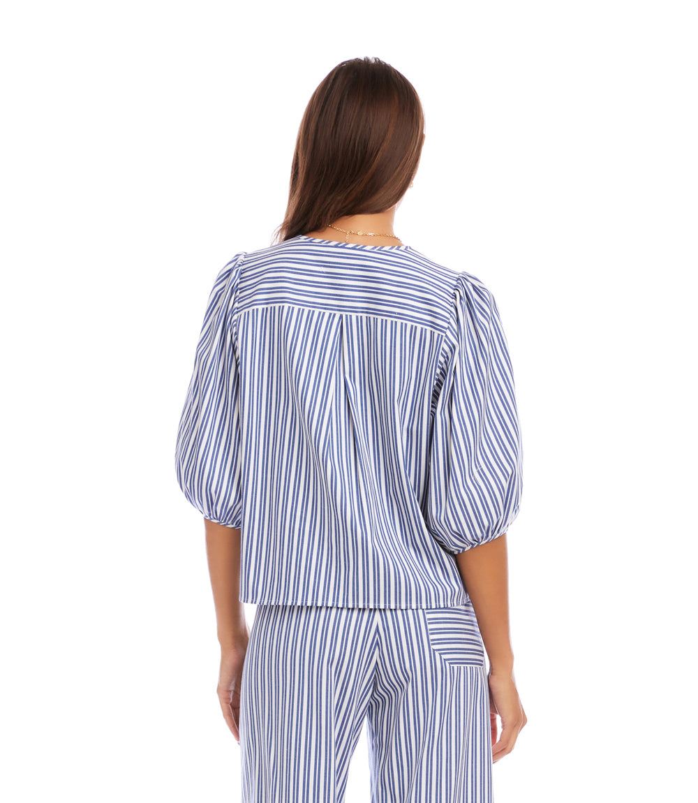Woman wearing a blue and white striped outfit on a white background