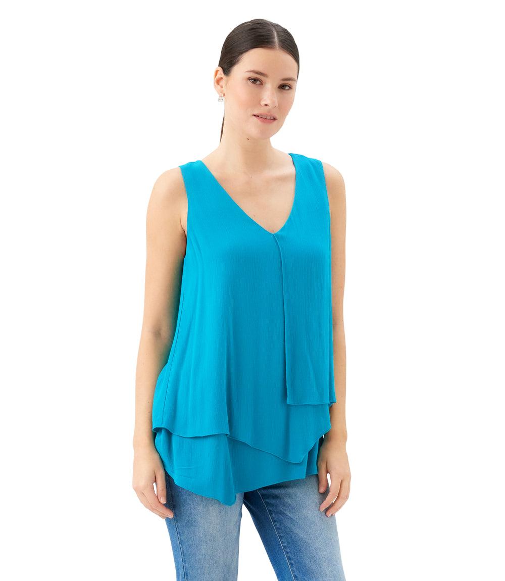 Woman wearing a turquoise sleeveless top on a white background