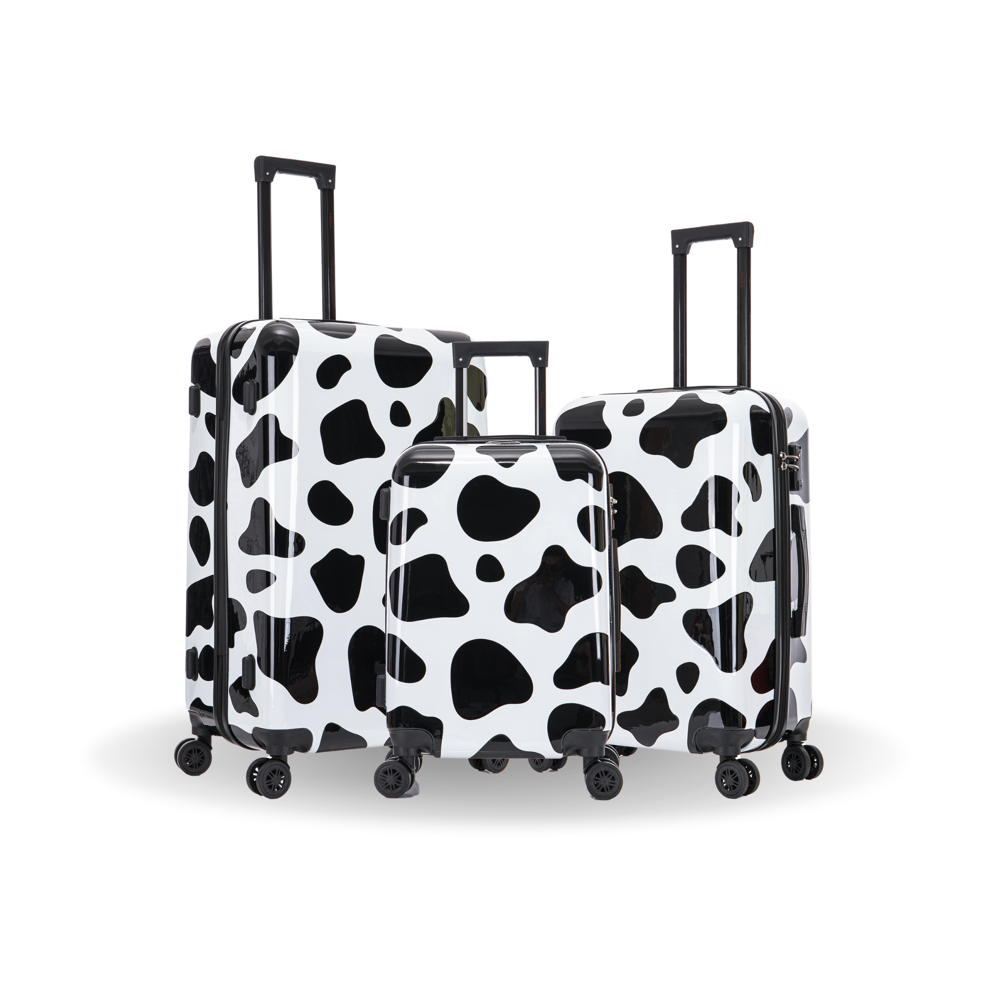 Set of two black and white cow print suitcases on a white background