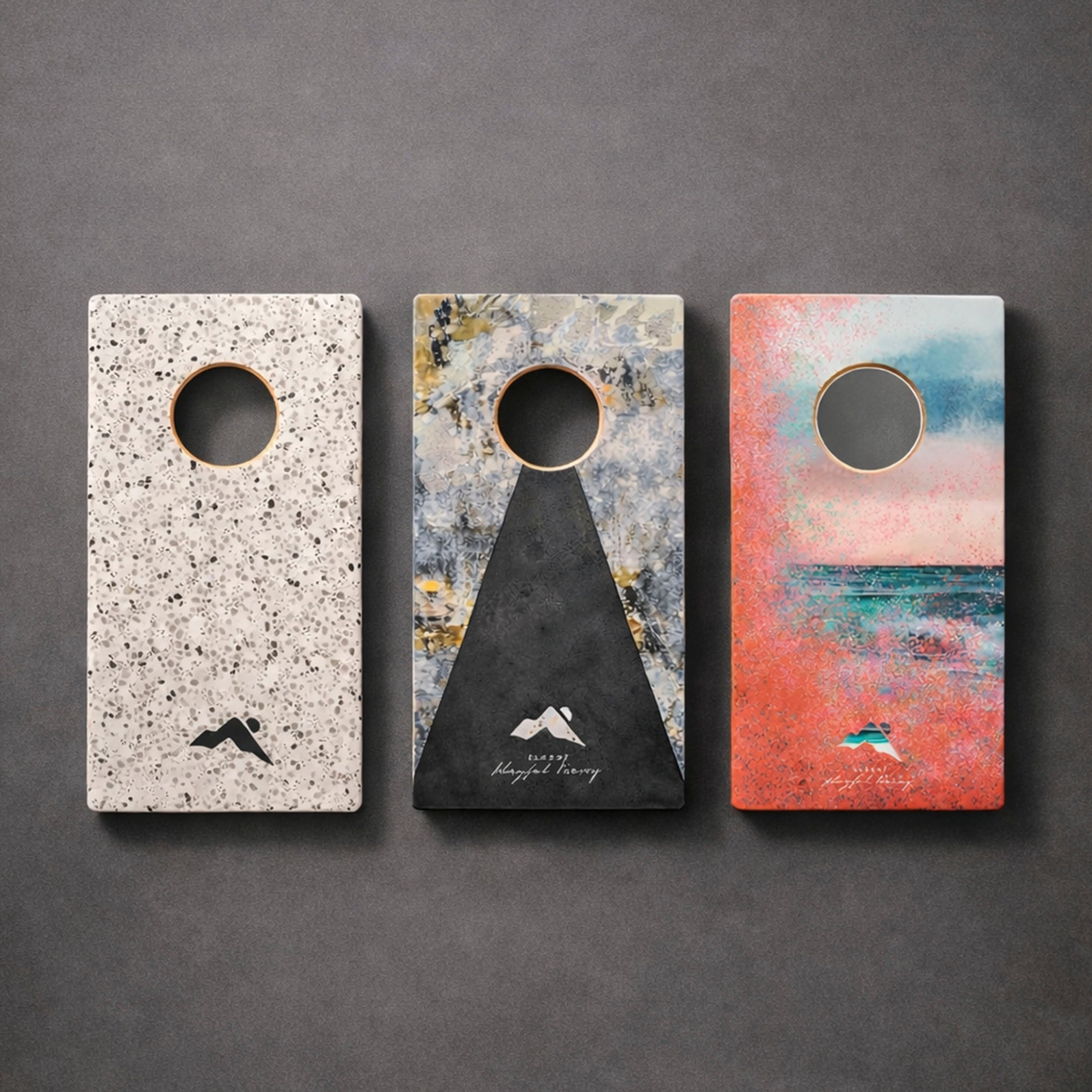 Three decorative door hangers with artistic designs on a gray background