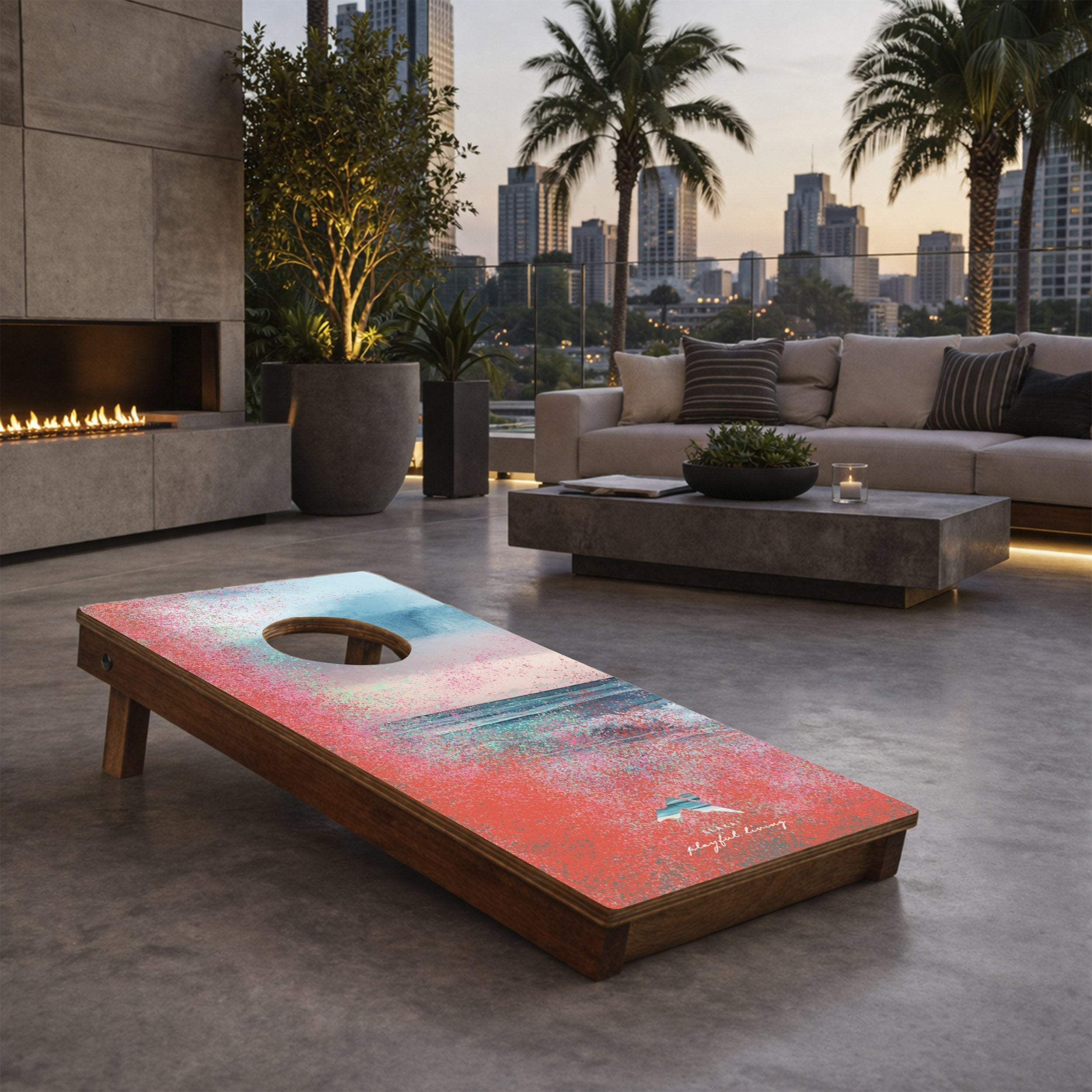 Cornhole board with colorful design on a patio with city skyline in the background