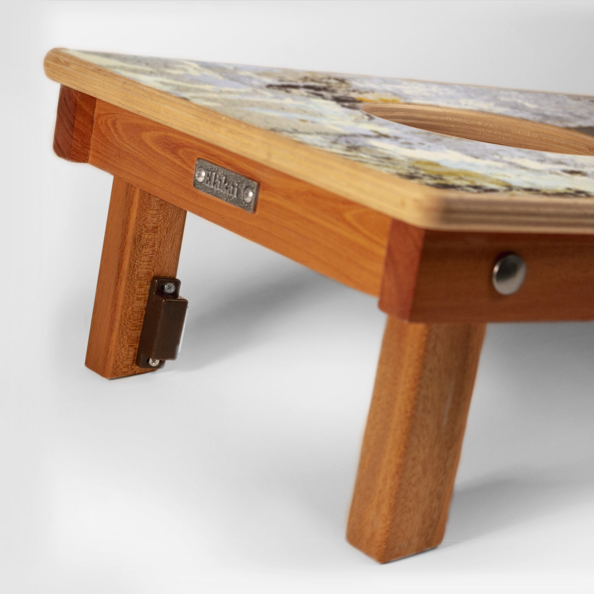 Wooden footstool with a patterned top on a white background