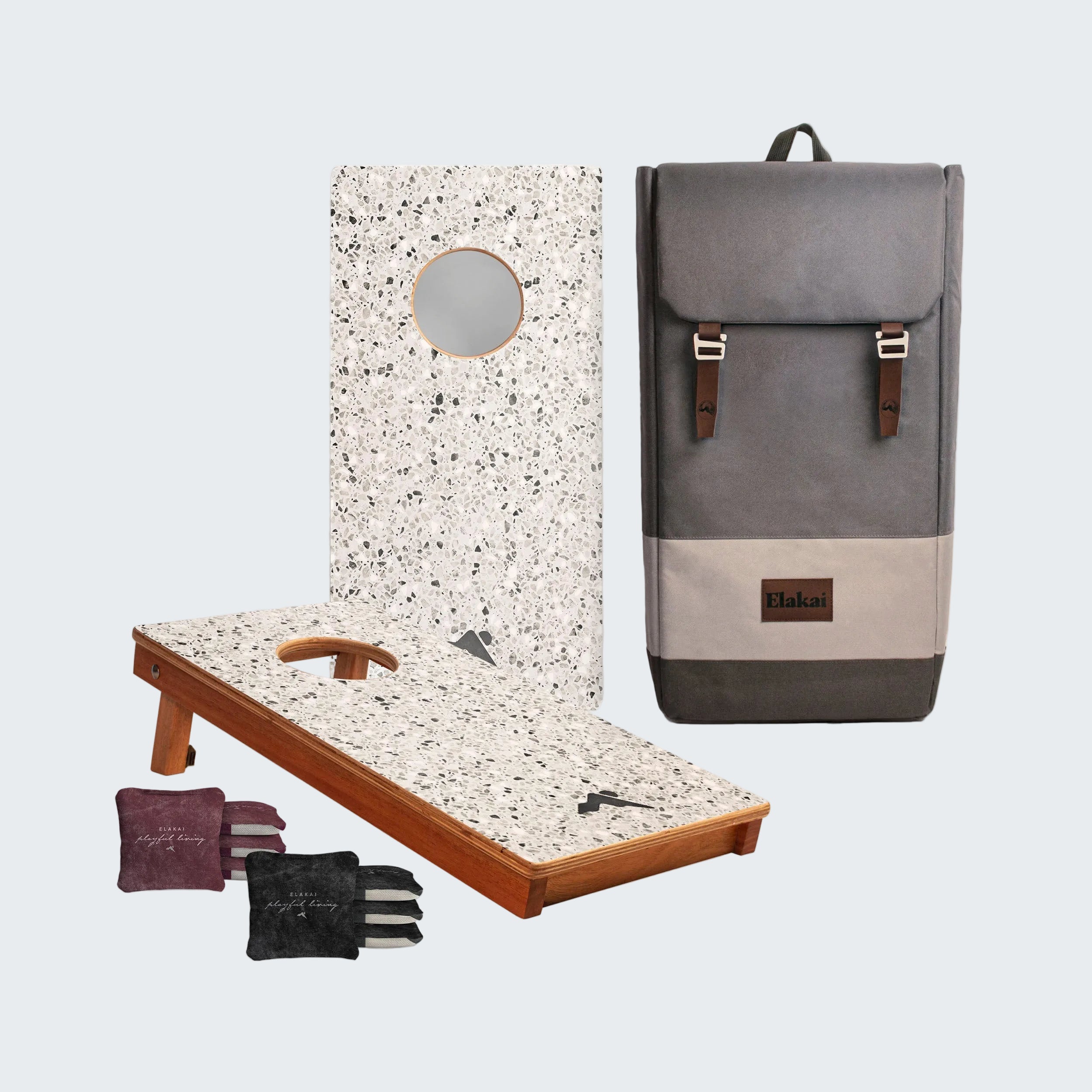 Cornhole board with bags and a gray backpack on a white background