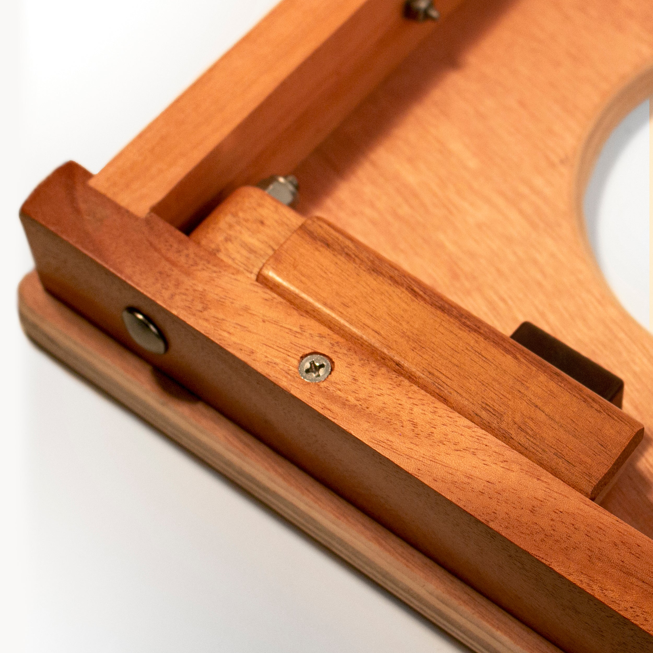Close-up of a wooden frame with a white circle inside on a light gray background