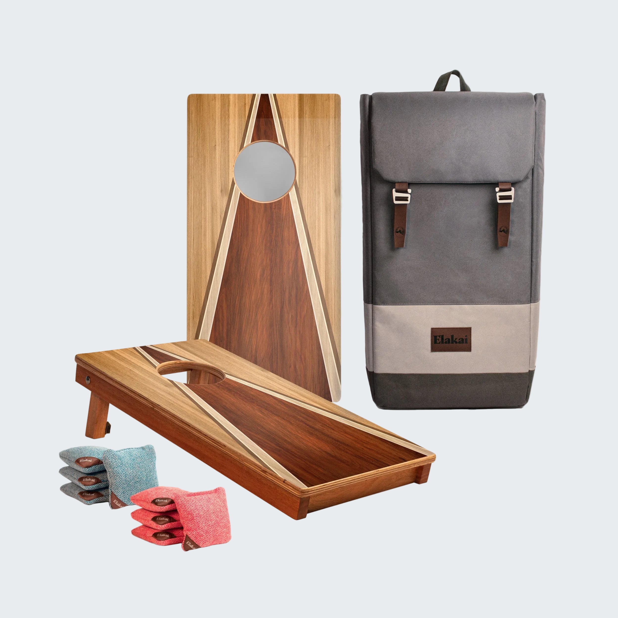 Wooden cornhole boards with bags and a gray backpack on a white background