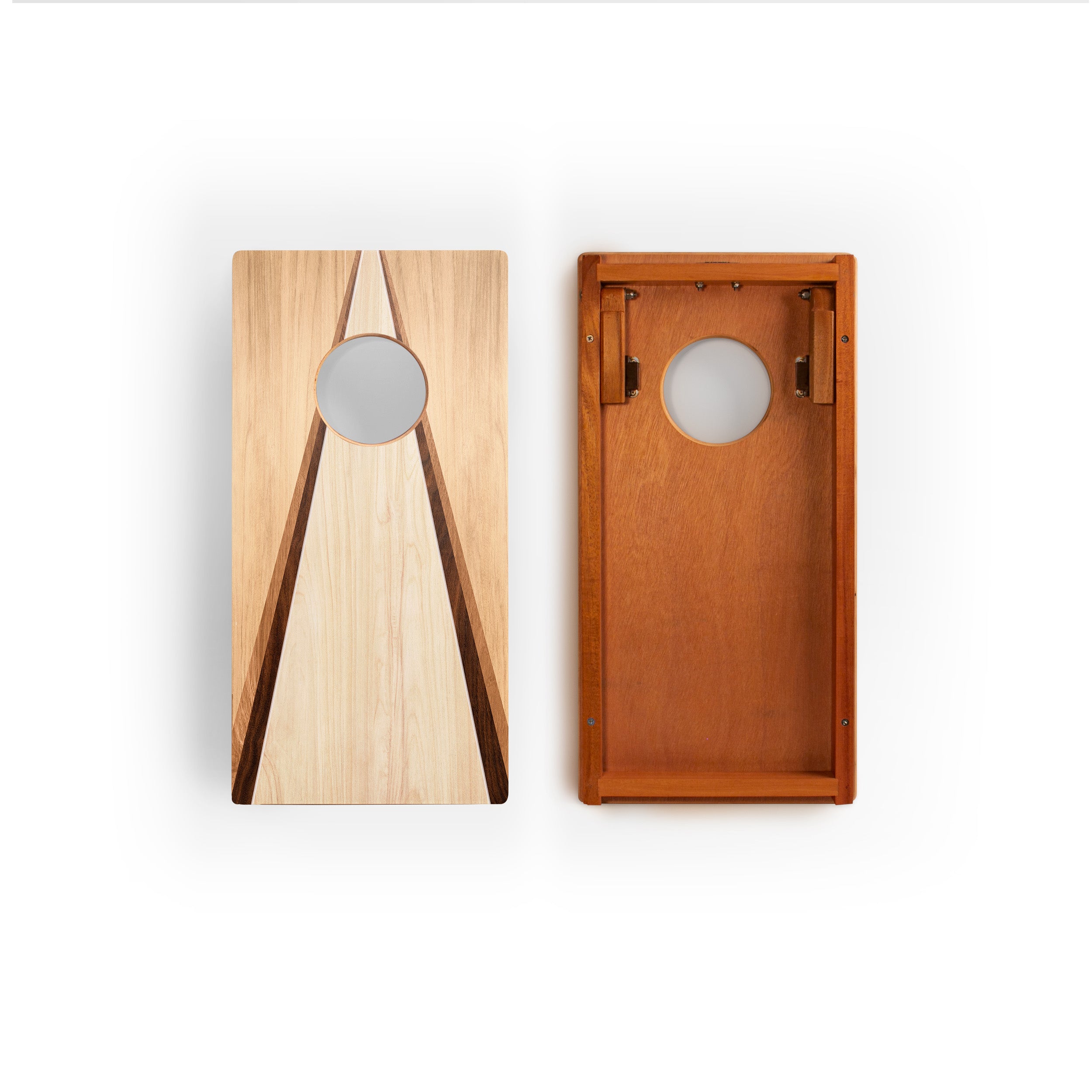 Two wooden cornhole boards shown side by side on a white background, one displaying the light natural wood grain with a circular scoring hole, and the other showing the warm medium-brown wood grain interior with metal corner supports.