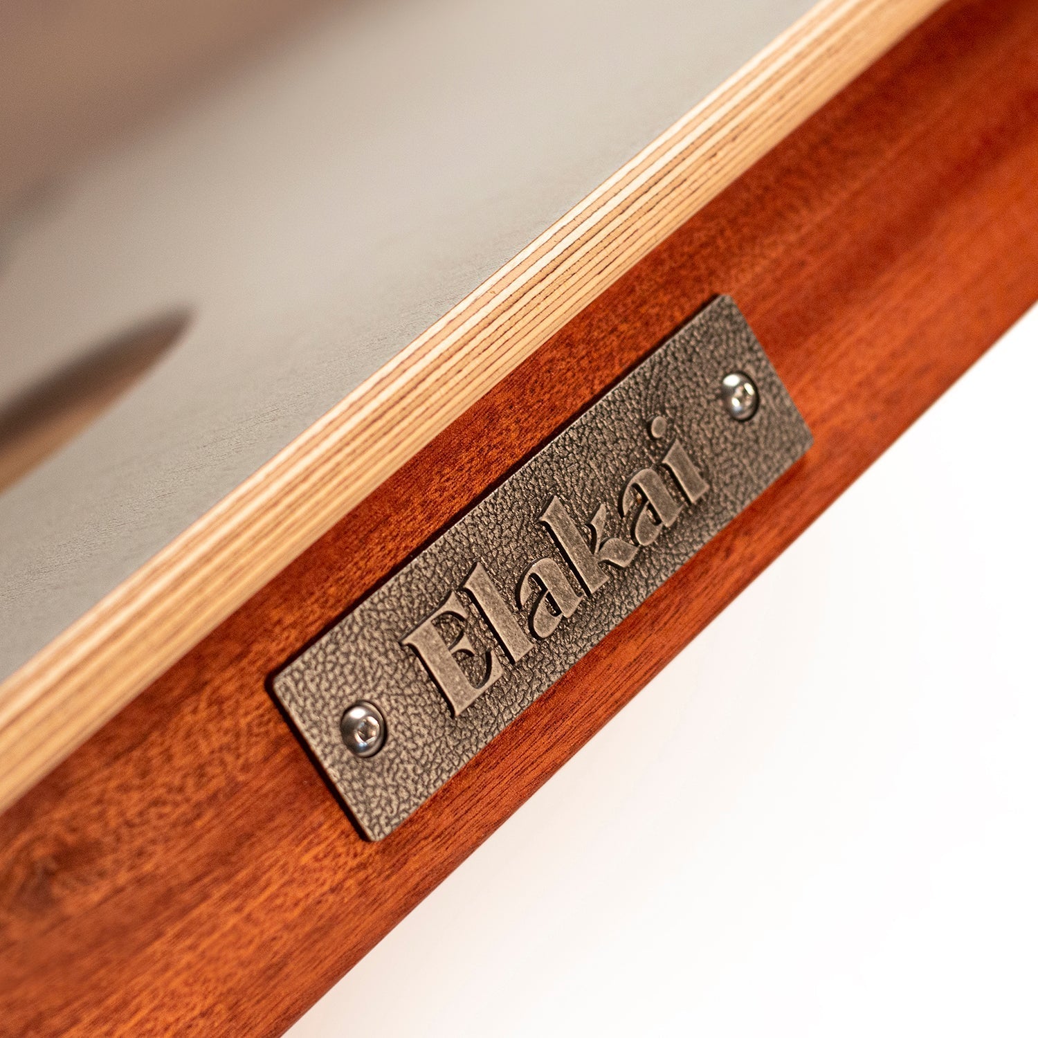 Wooden product with a metal 'Elakai' label on a neutral background