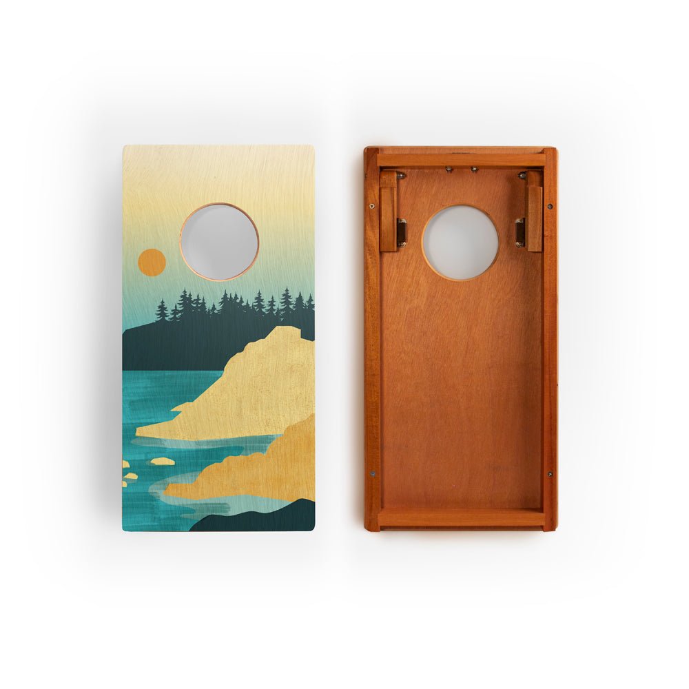 Two cornhole boards with nature-themed designs on a white background