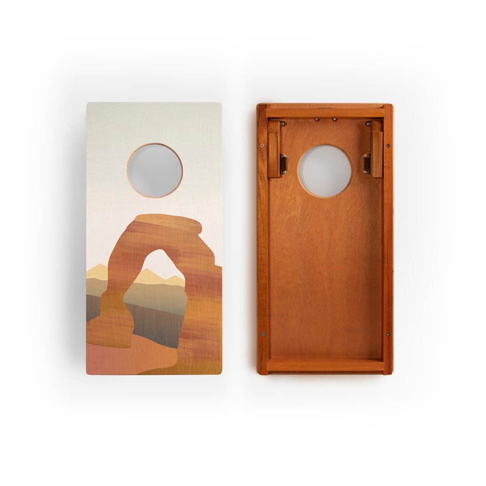 Two wooden cornhole boards with artistic designs on a white background