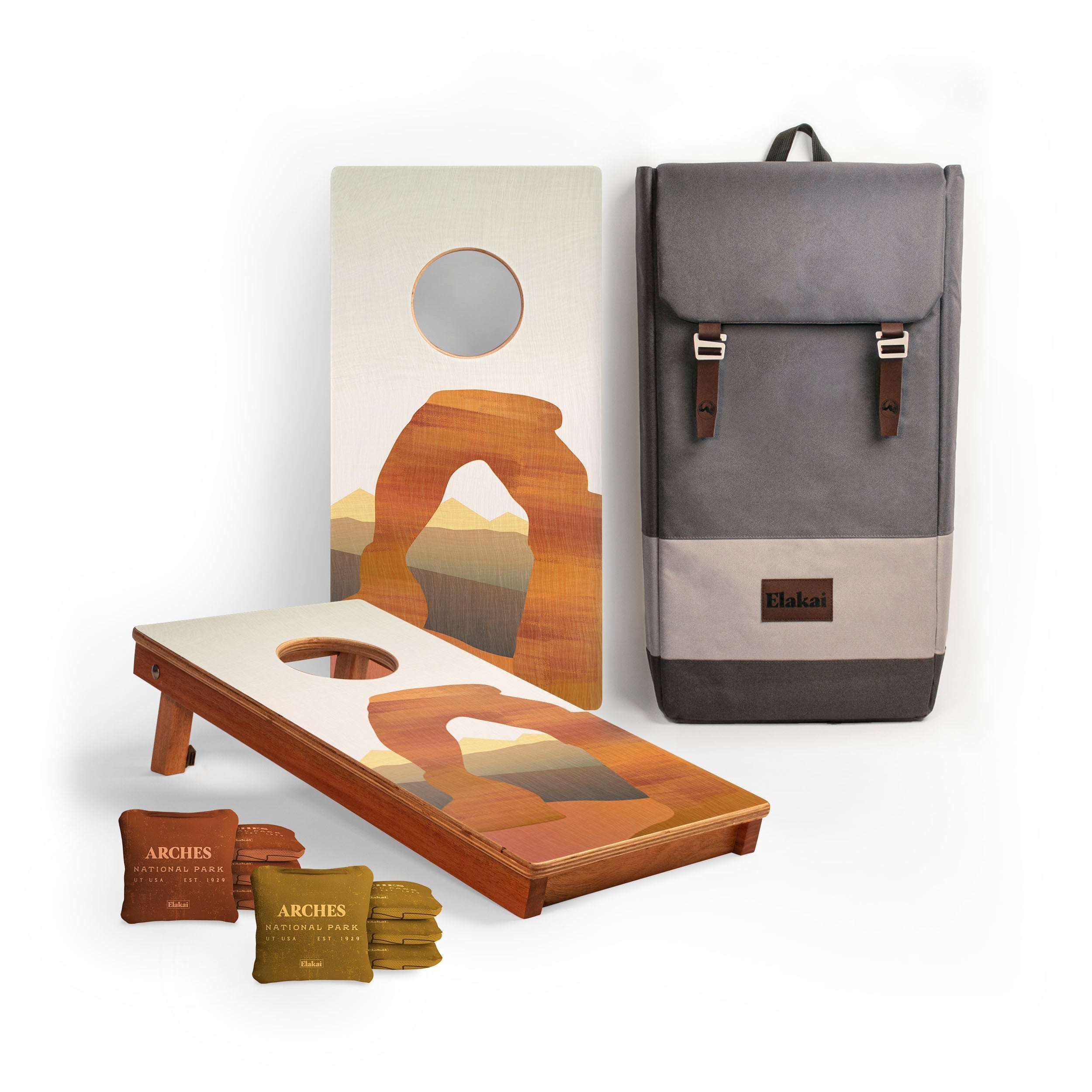 Cornhole board with desert-themed design, backpack, and cornhole bags on a white background