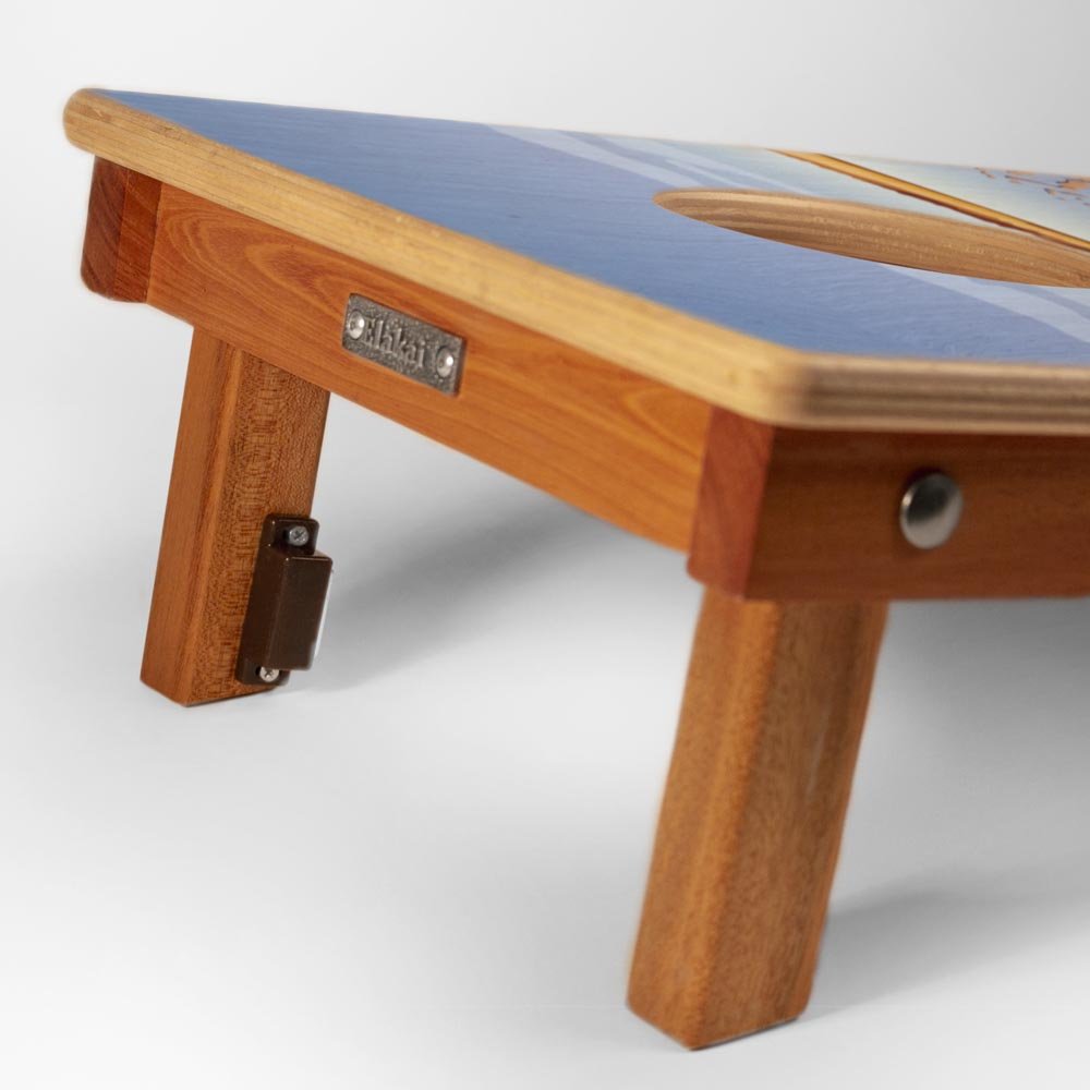 Wooden footstool with a blue cushion on a white background