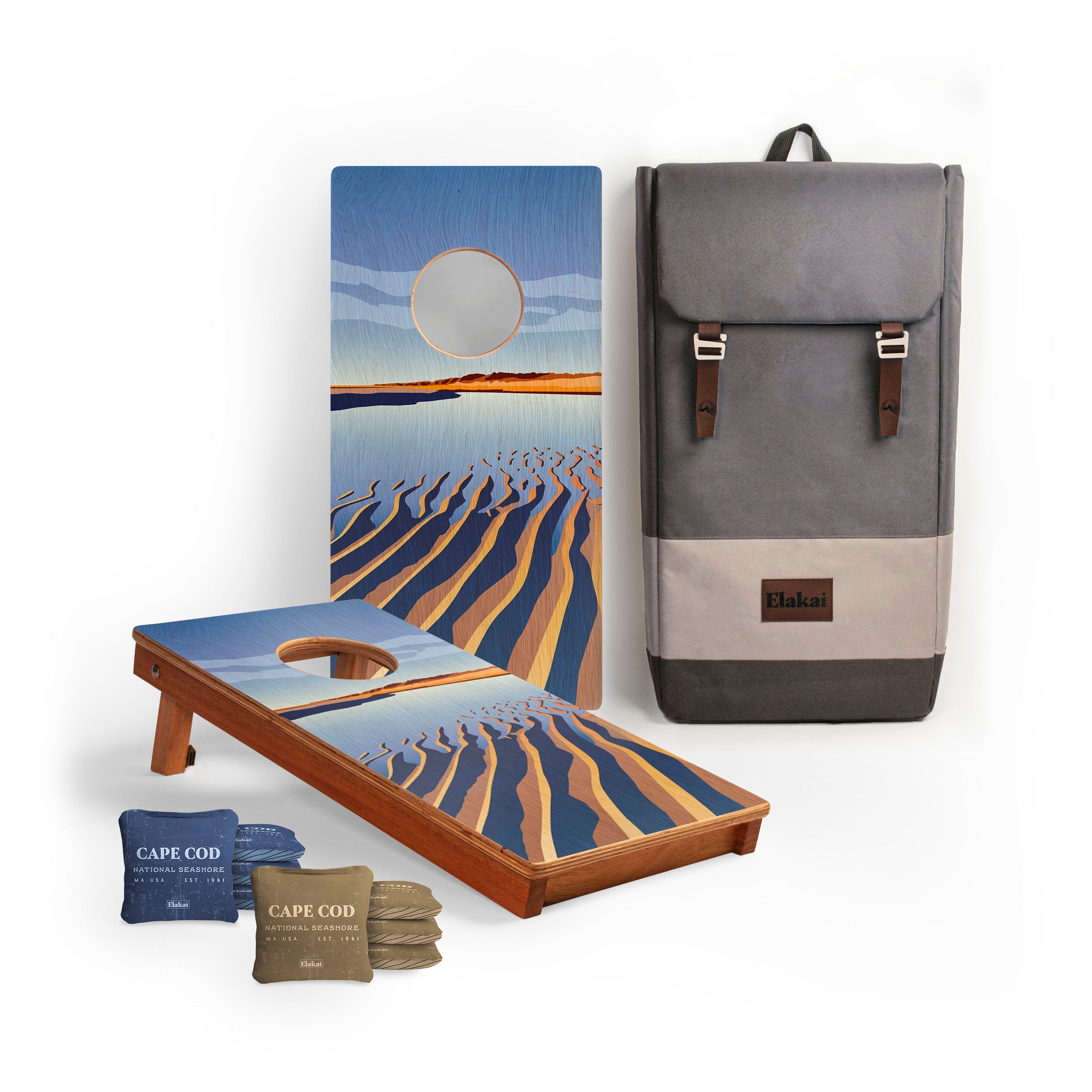Cornhole boards with beach design, bean bags, and a backpack on a white background