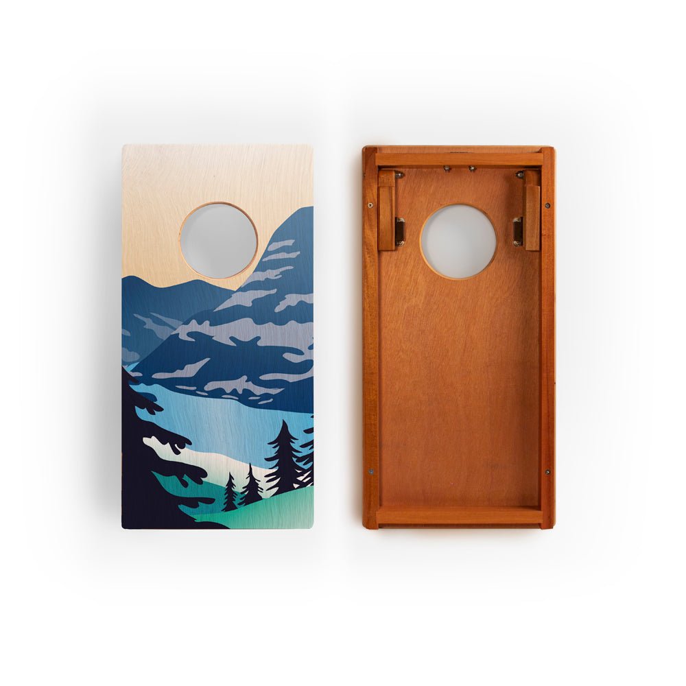 Two wooden cornhole boards with nature-themed designs on a white background