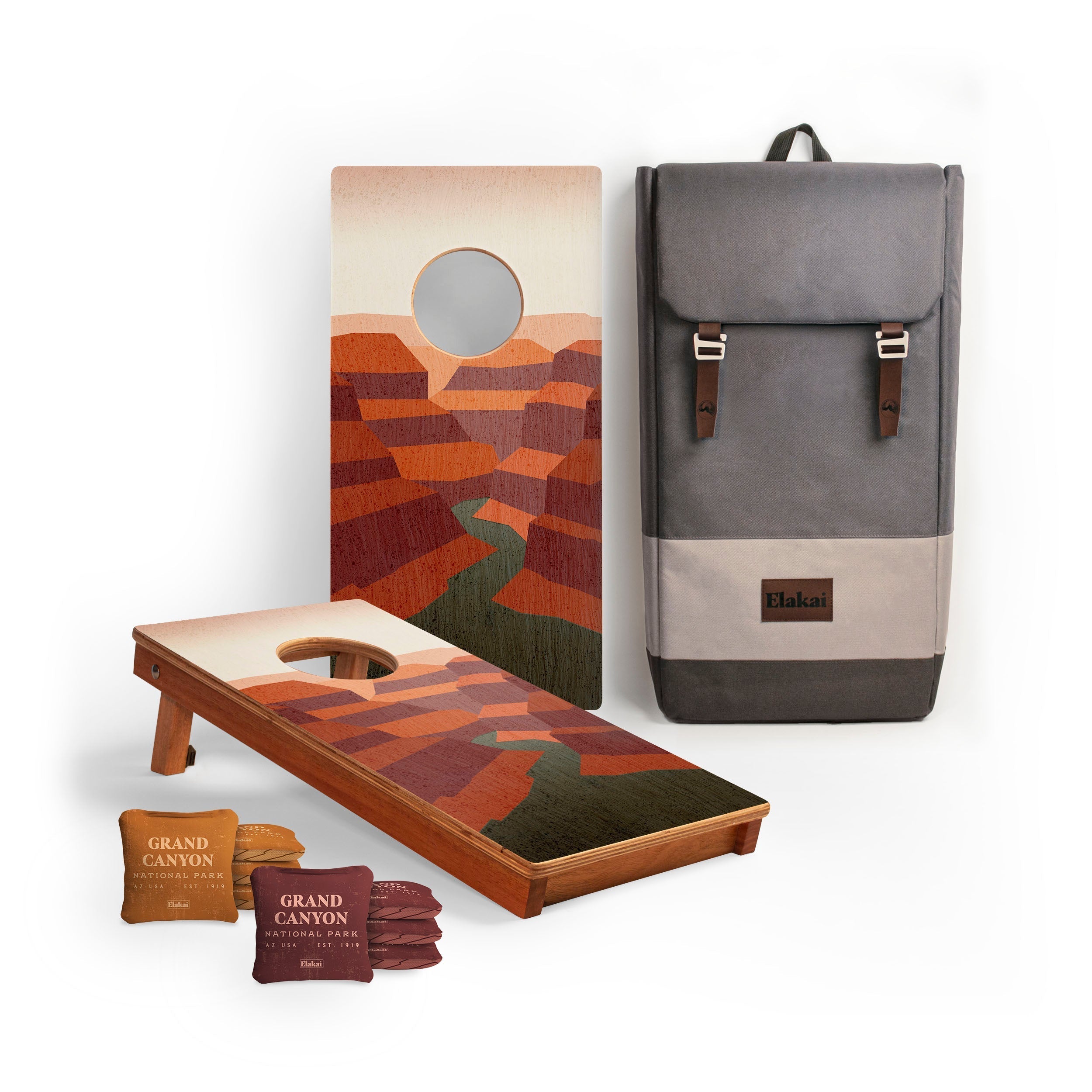 Cornhole boards with desert design, bean bags, and a backpack on a white background
