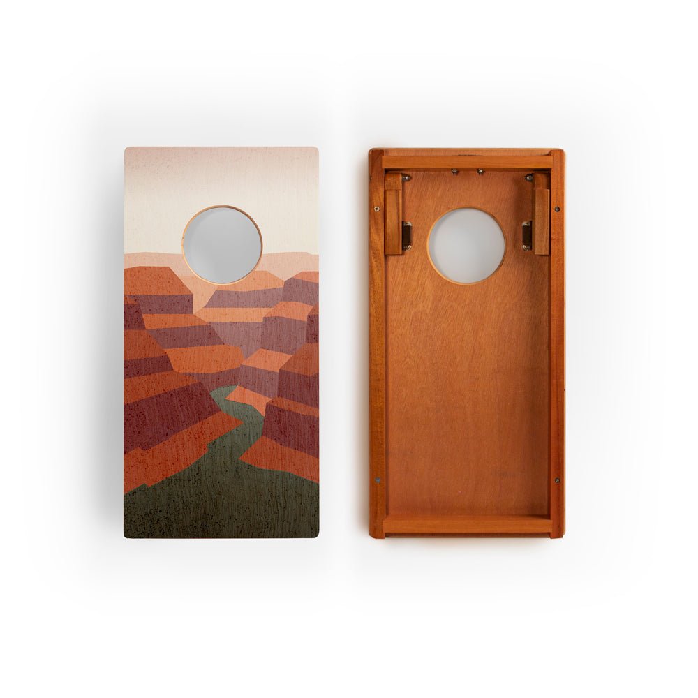 Two wooden cornhole boards with landscape design on a white background