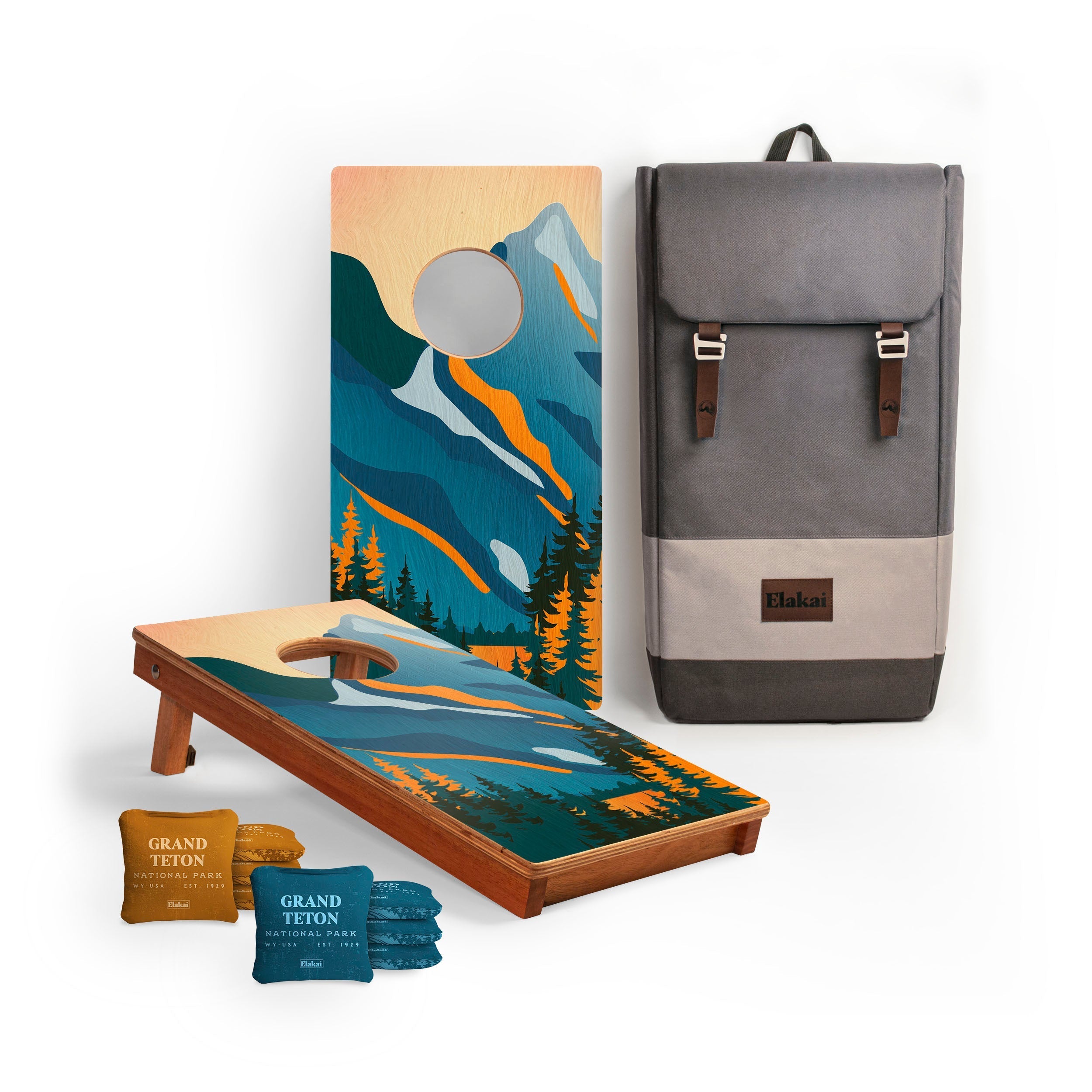 Cornhole boards with mountain design, bags, and a backpack on a white background