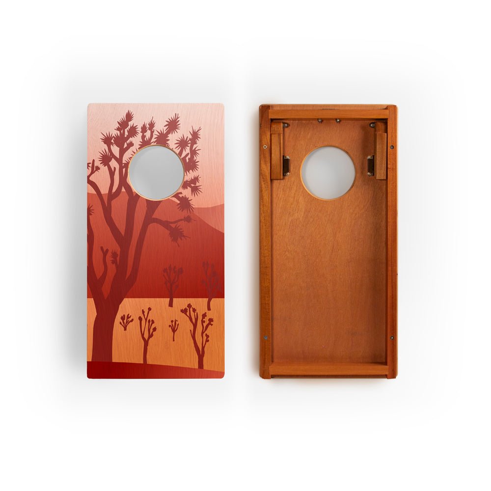 Two wooden cornhole boards with a desert landscape design on a white background