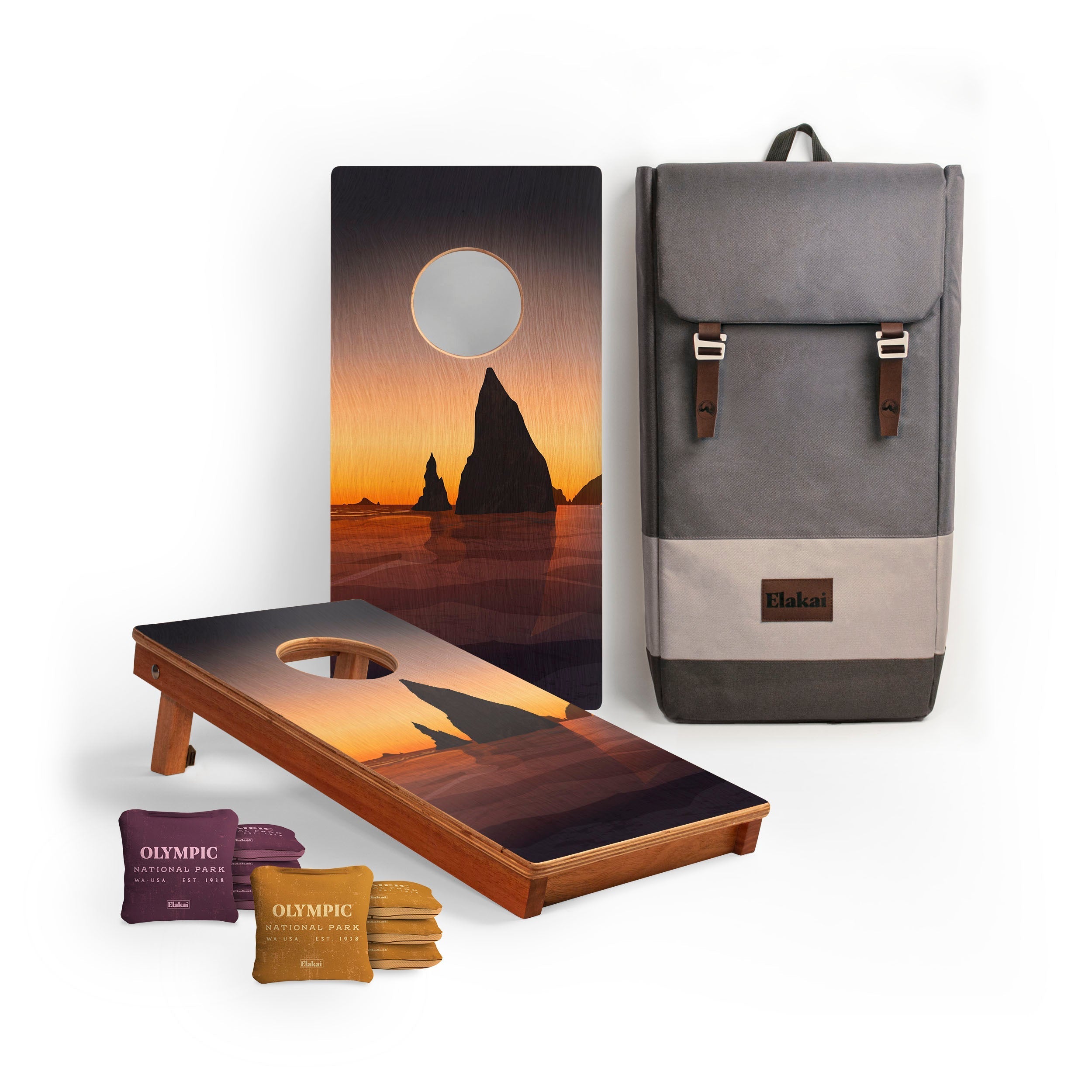 Cornhole boards with sunset design, backpack, and bags on a white background