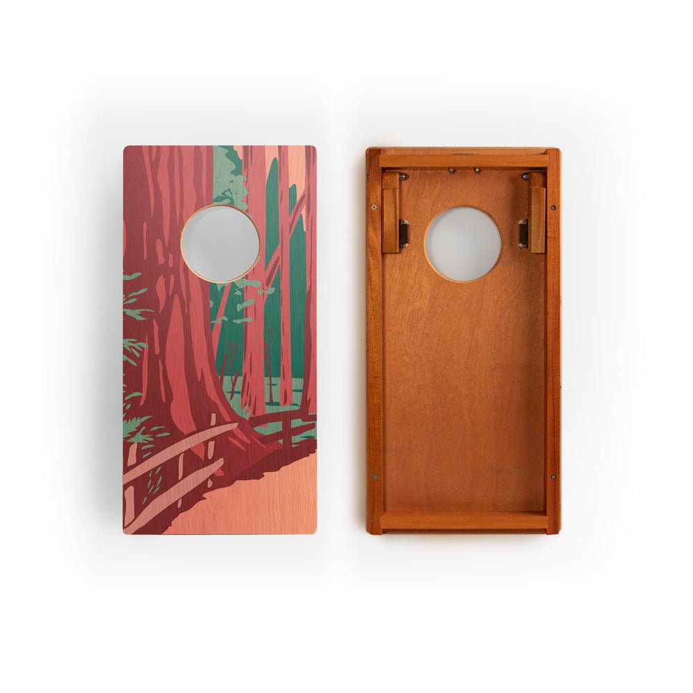 Two wooden cornhole boards with one featuring a nature-themed design.