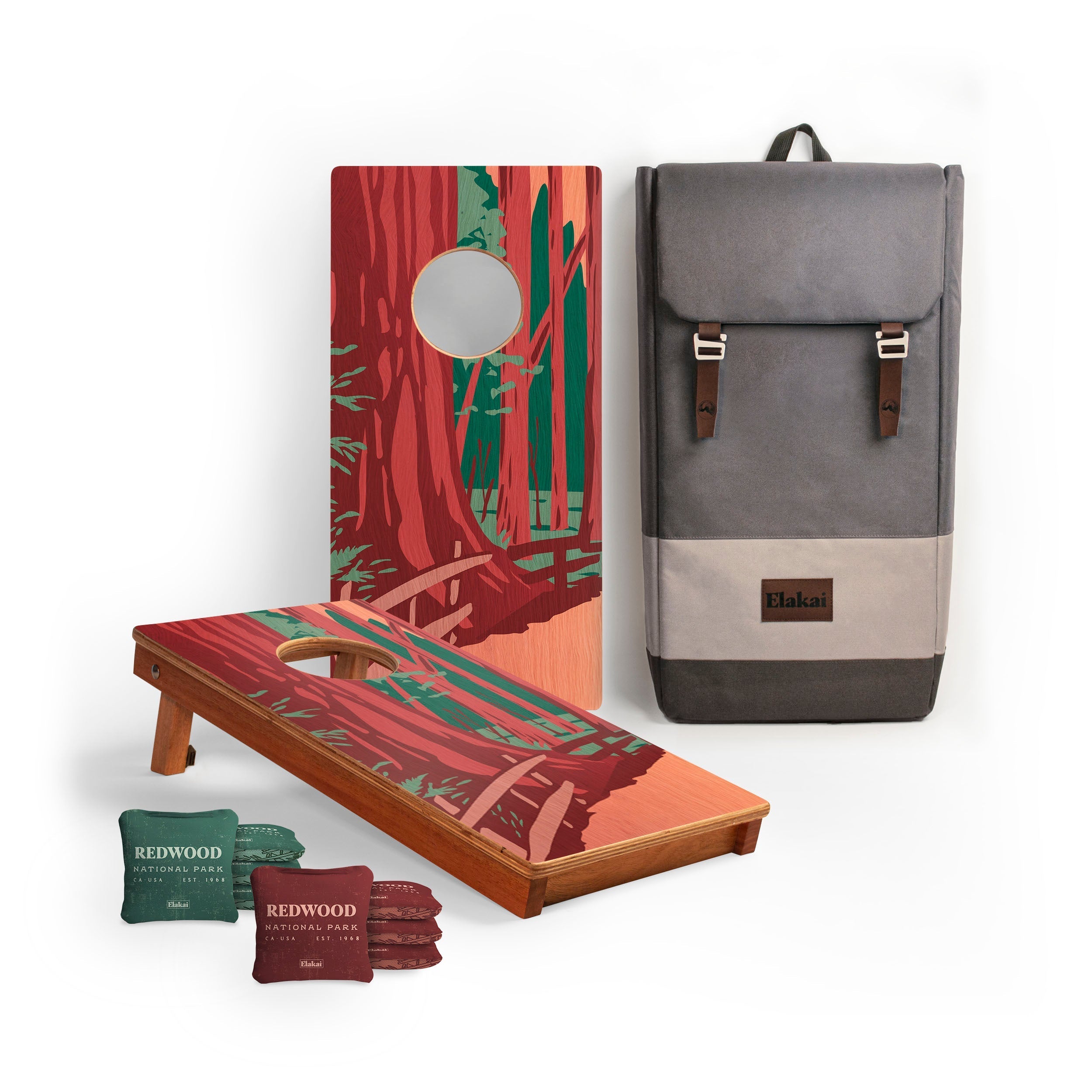 Cornhole boards with nature-themed design and a gray backpack on a white background