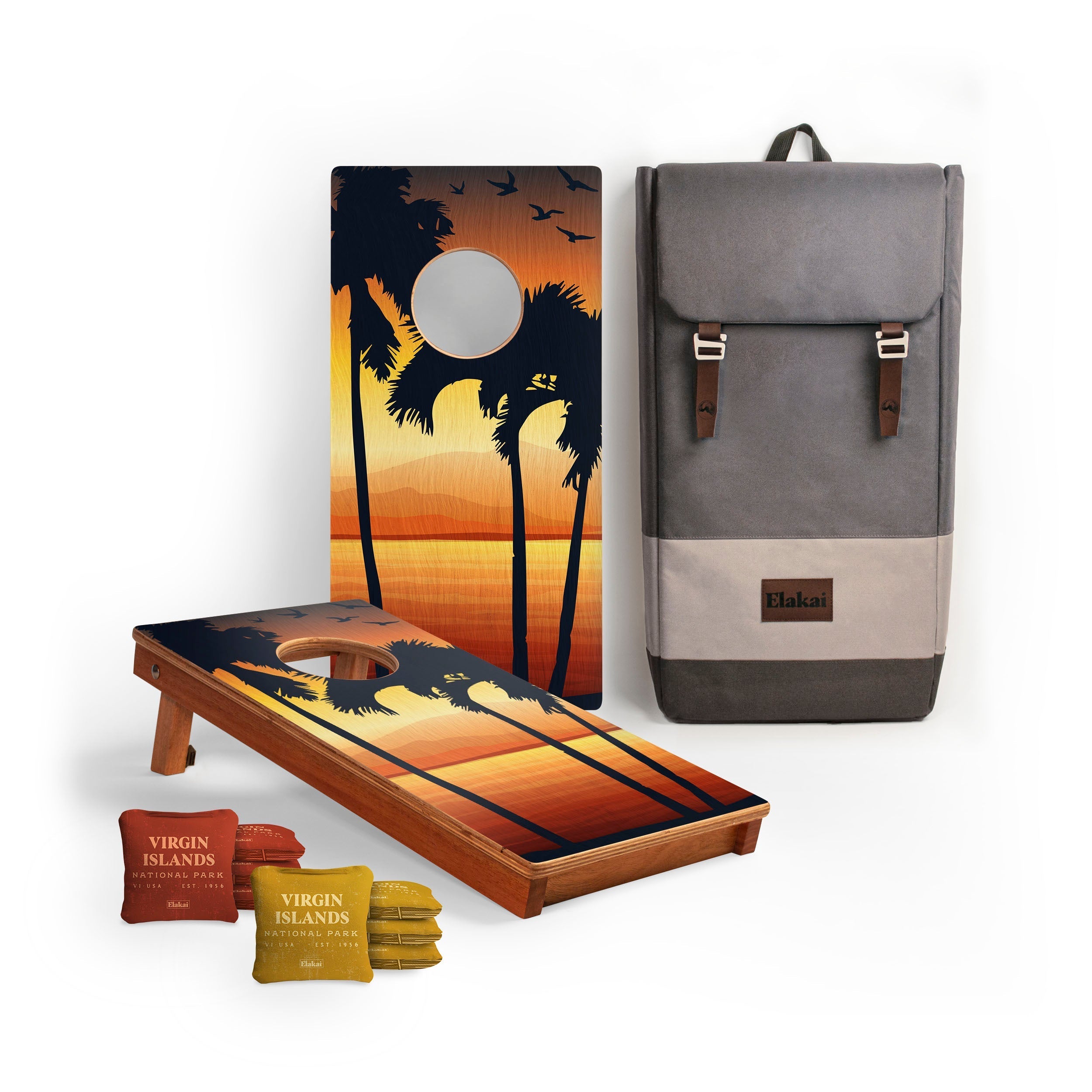 Cornhole board with sunset design, backpack, and bean bags on a white background