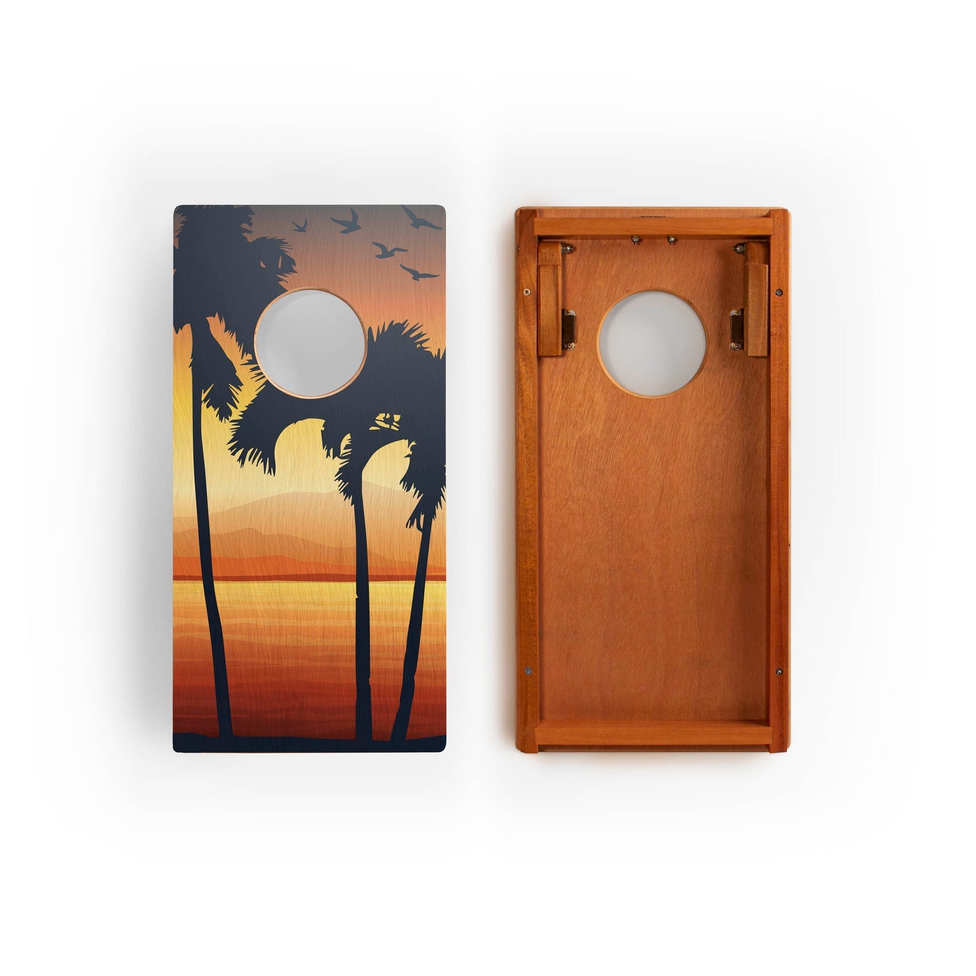 Two cornhole boards with sunset design featuring palm trees and birds.