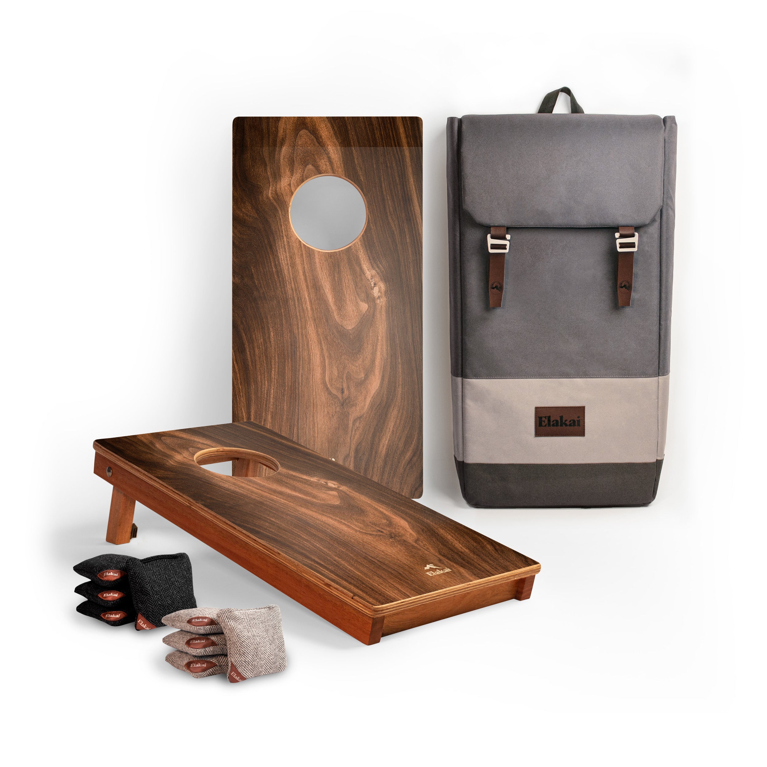 Wooden cornhole boards with bags and a gray backpack on a white background