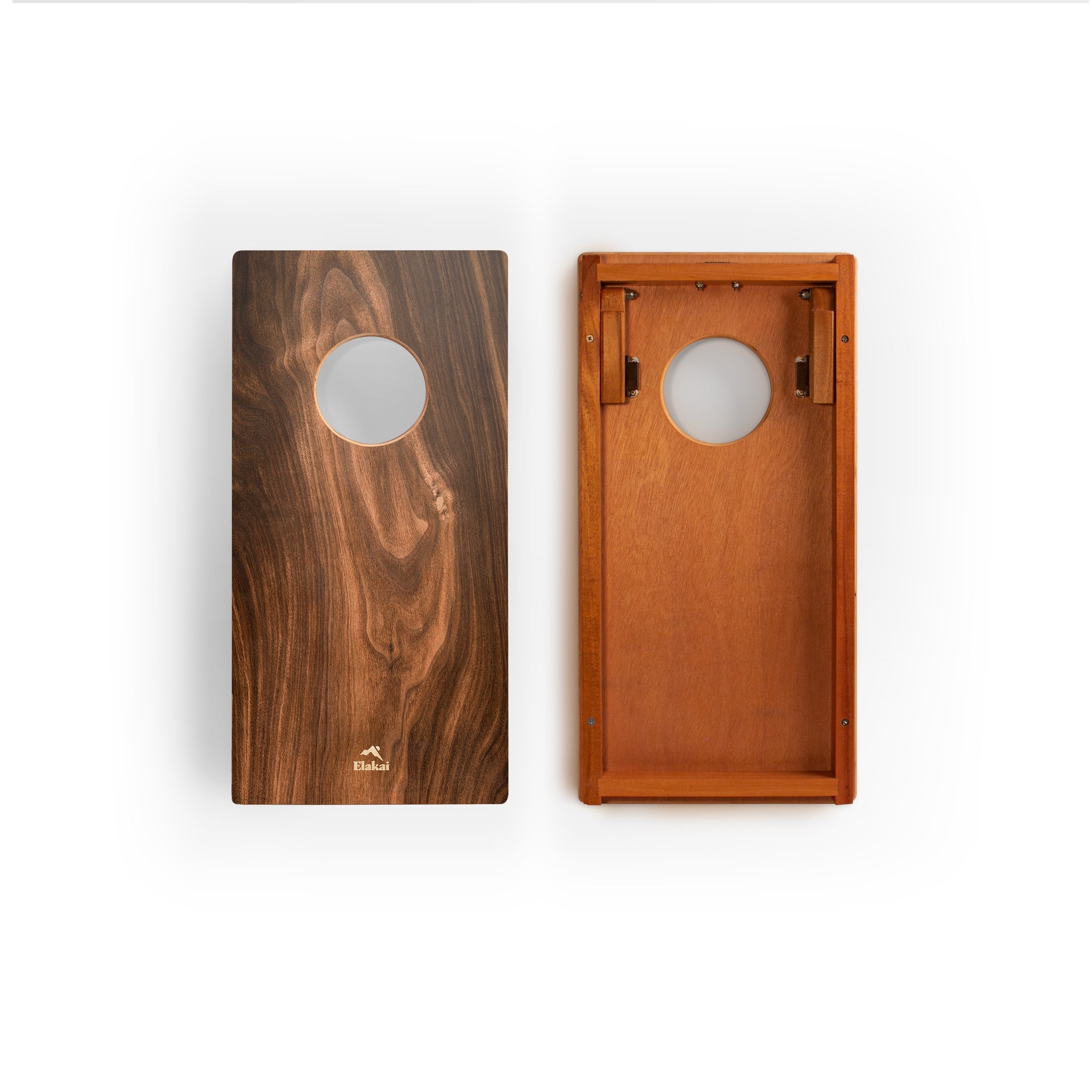 Two wooden cornhole boards shown side by side on a white background, one displaying a dark brown wood grain finish and the other showing a warm medium brown finish with brass hardware.