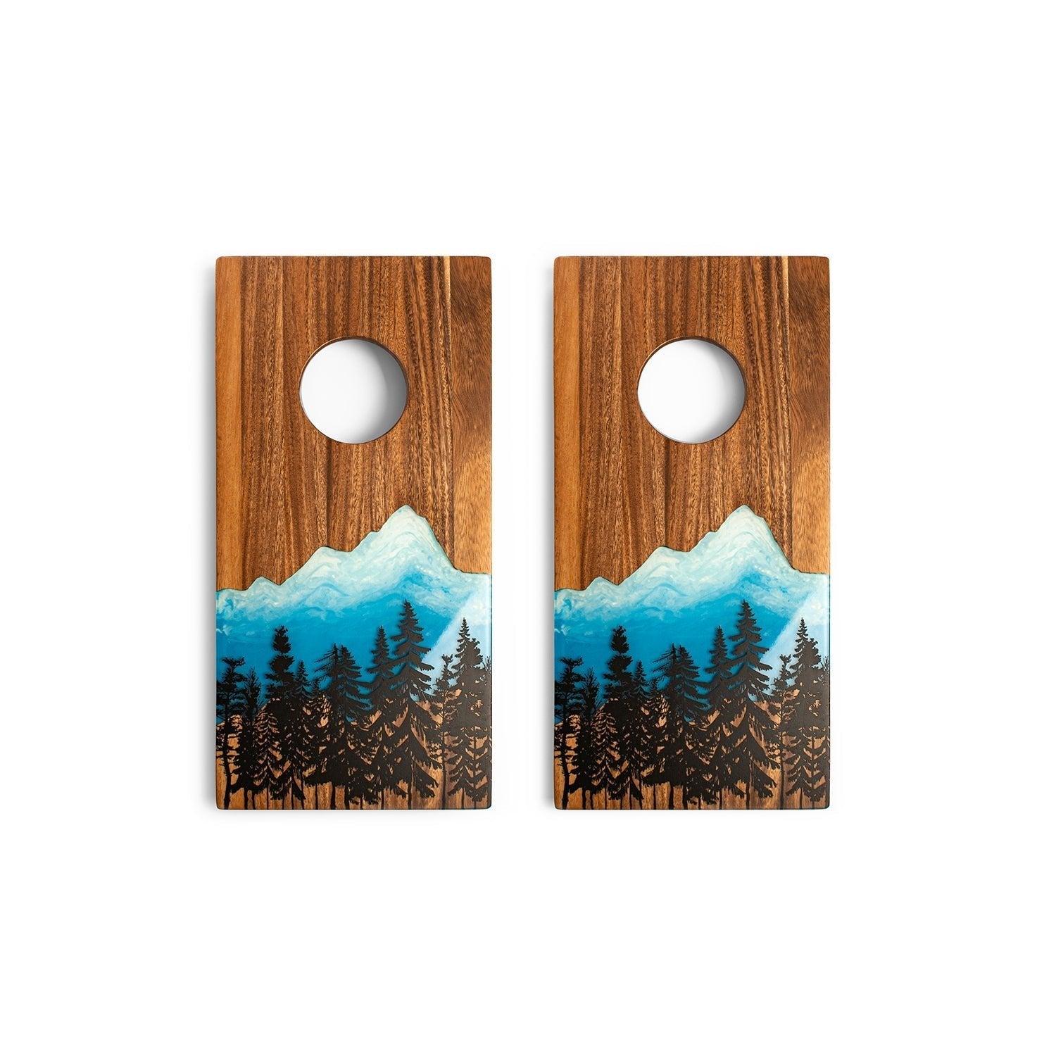 Two wooden cornhole boards with mountain and forest design on a white background