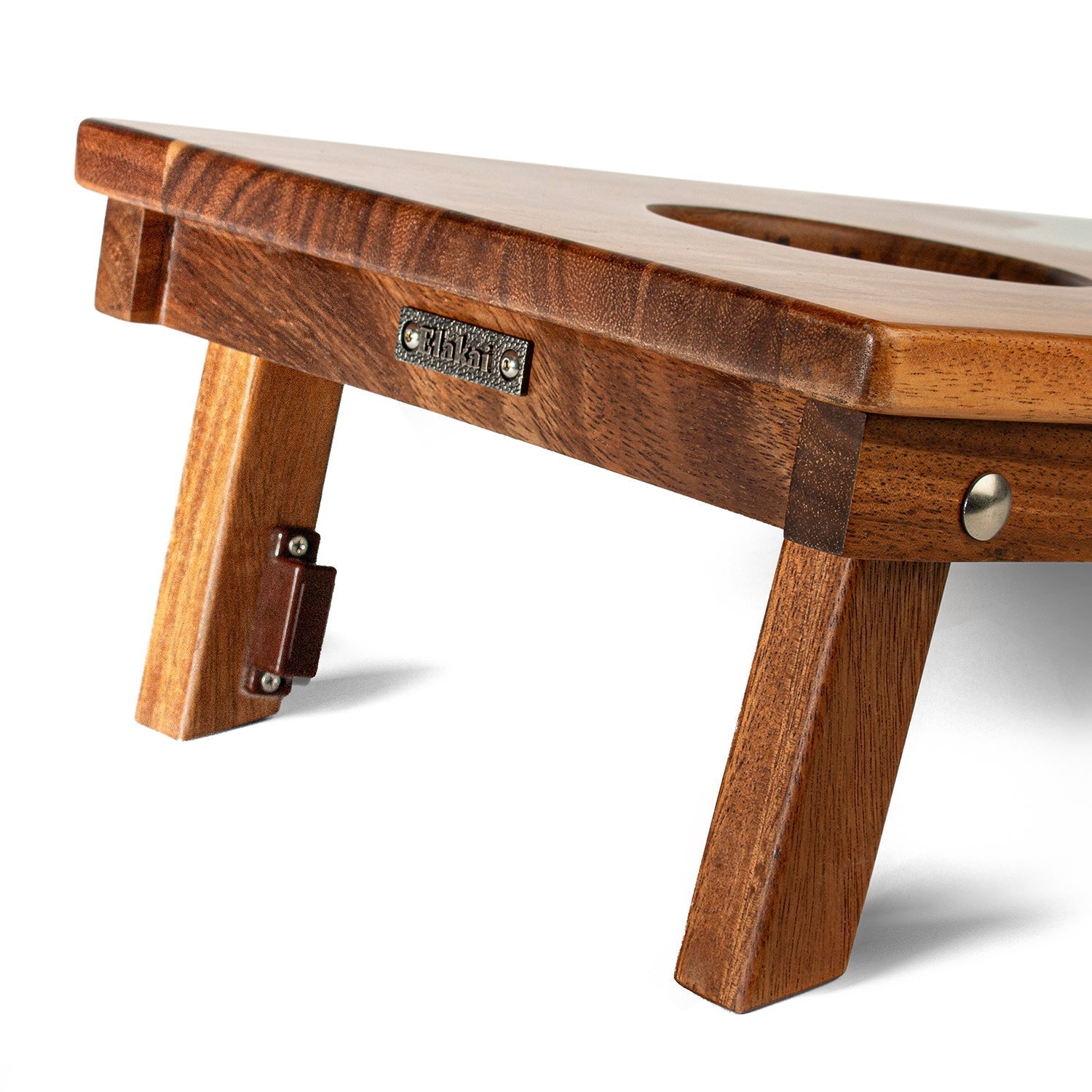 Wooden footstool with a metal plate on a white background