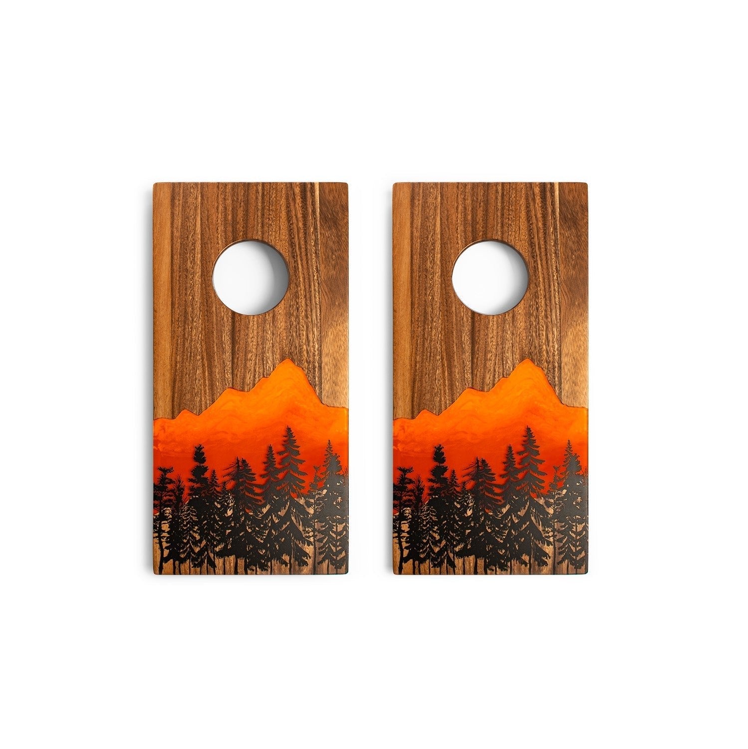Two wooden cornhole boards with a sunset and forest design on a white background.