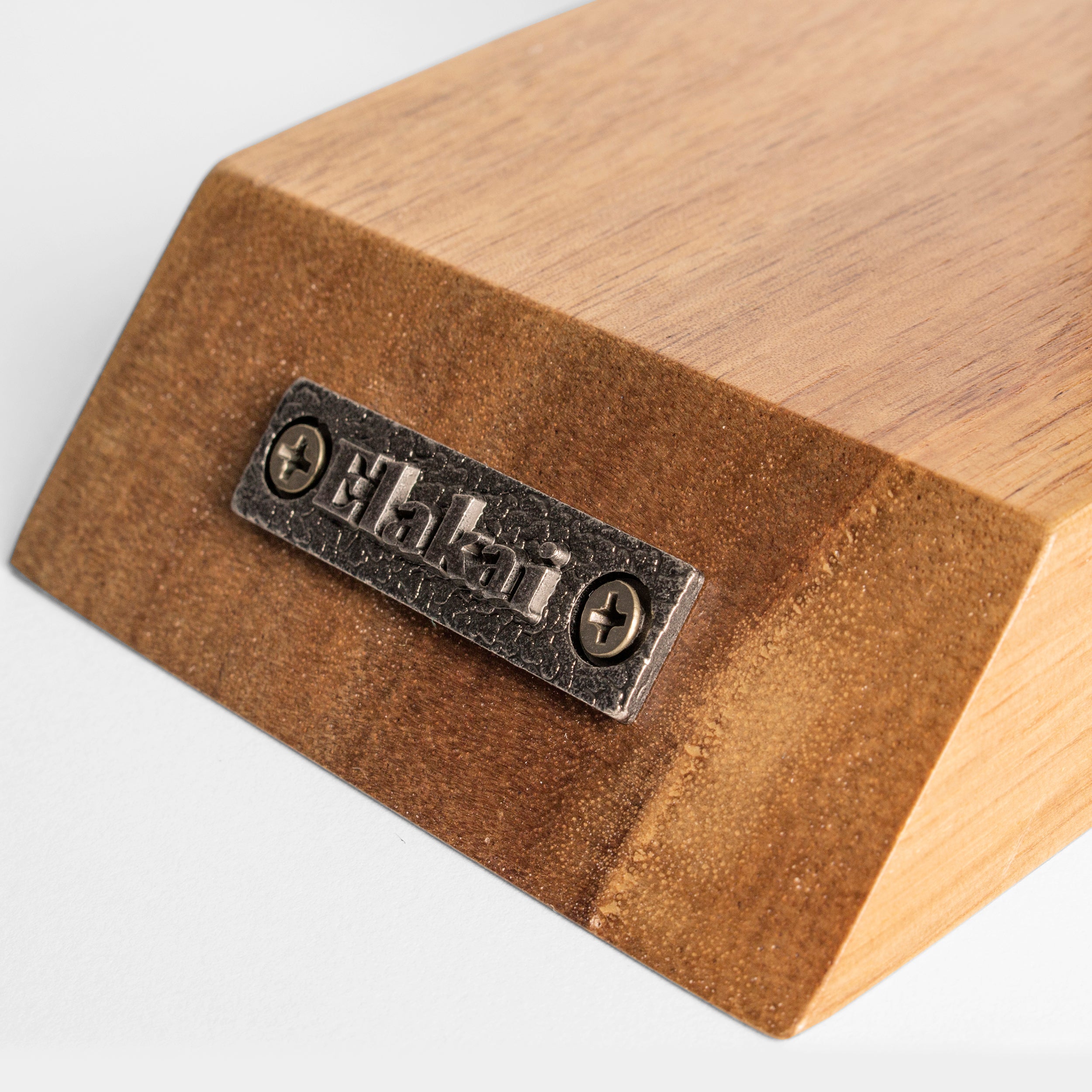 Wooden block with a metal label on a light gray background