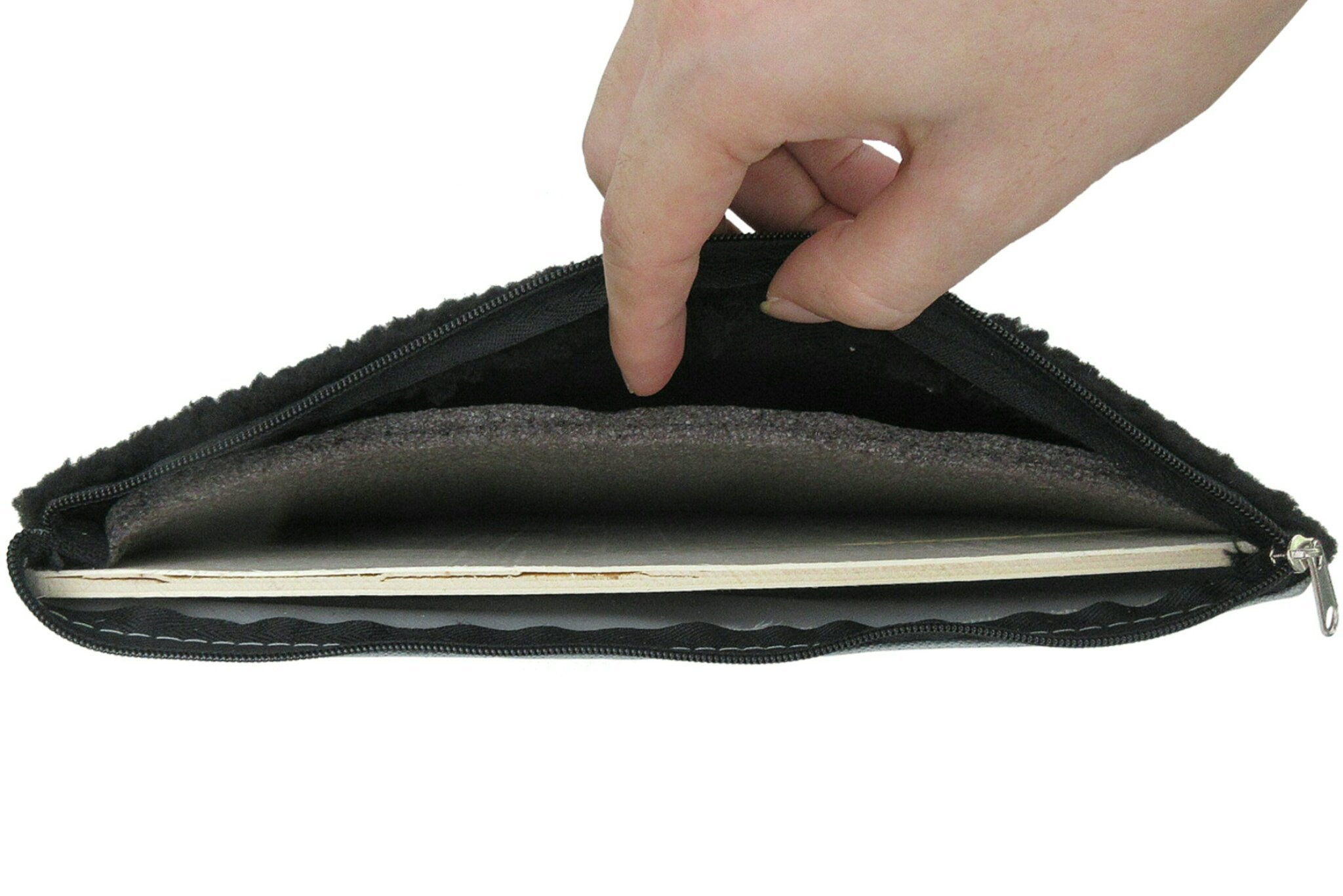 Hand opening a black zippered pouch on a white background