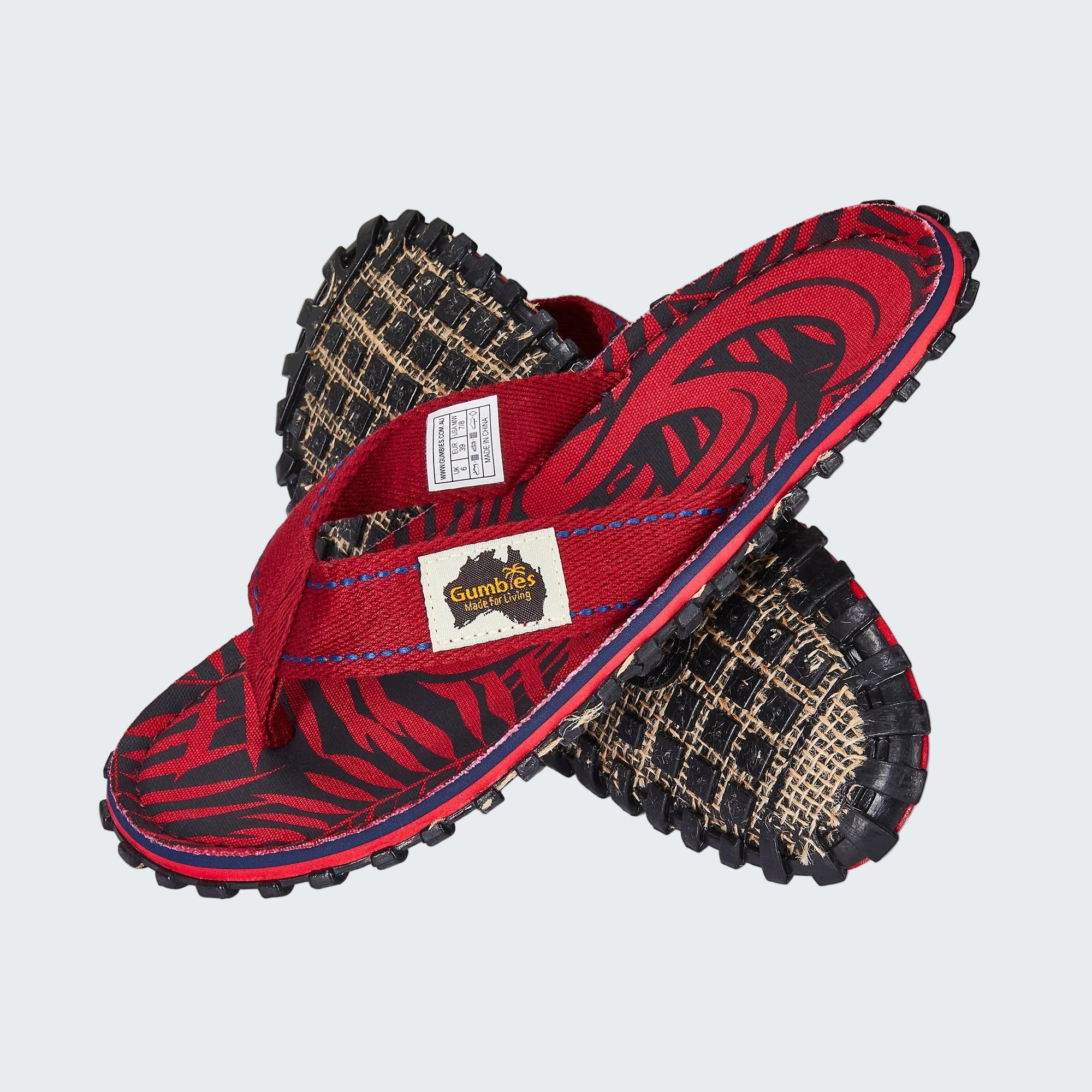 Red sandals with black and brown patterned soles on a white background