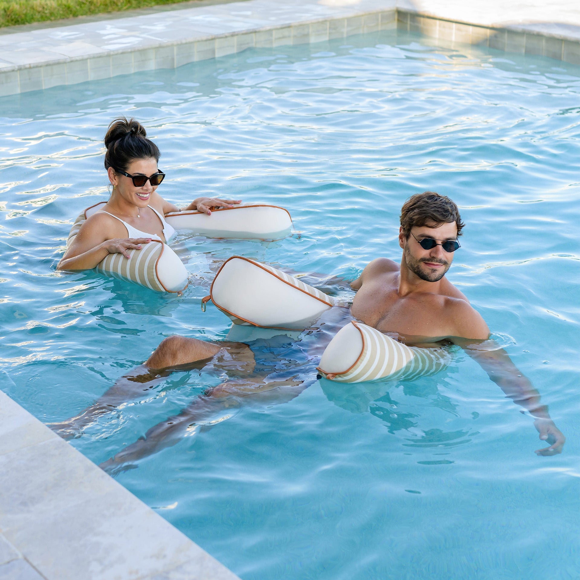 Two people in a pool with white circular floaties.