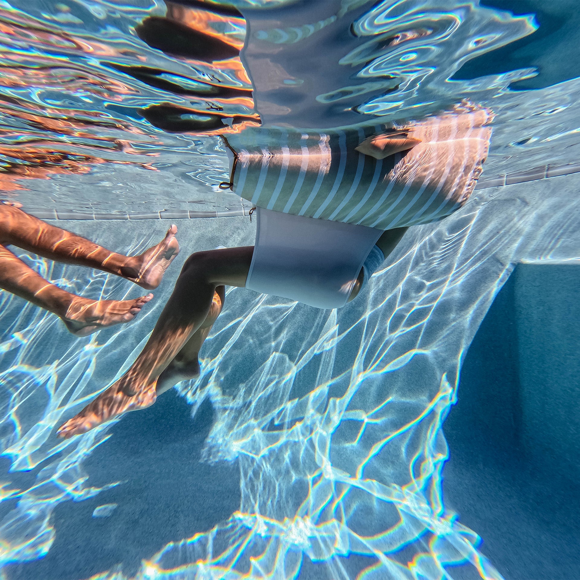 Person swimming underwater with clear blue water
