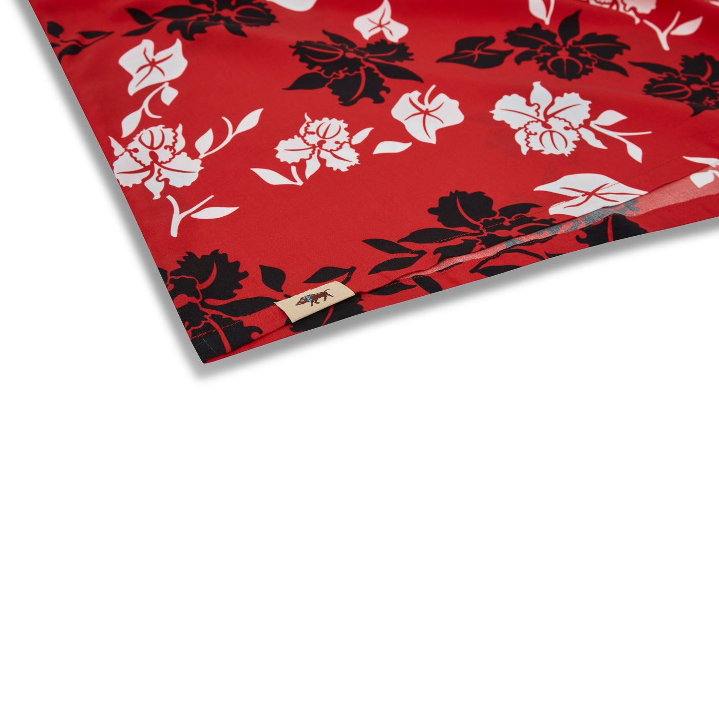 Red fabric with black and white floral patterns on a white background