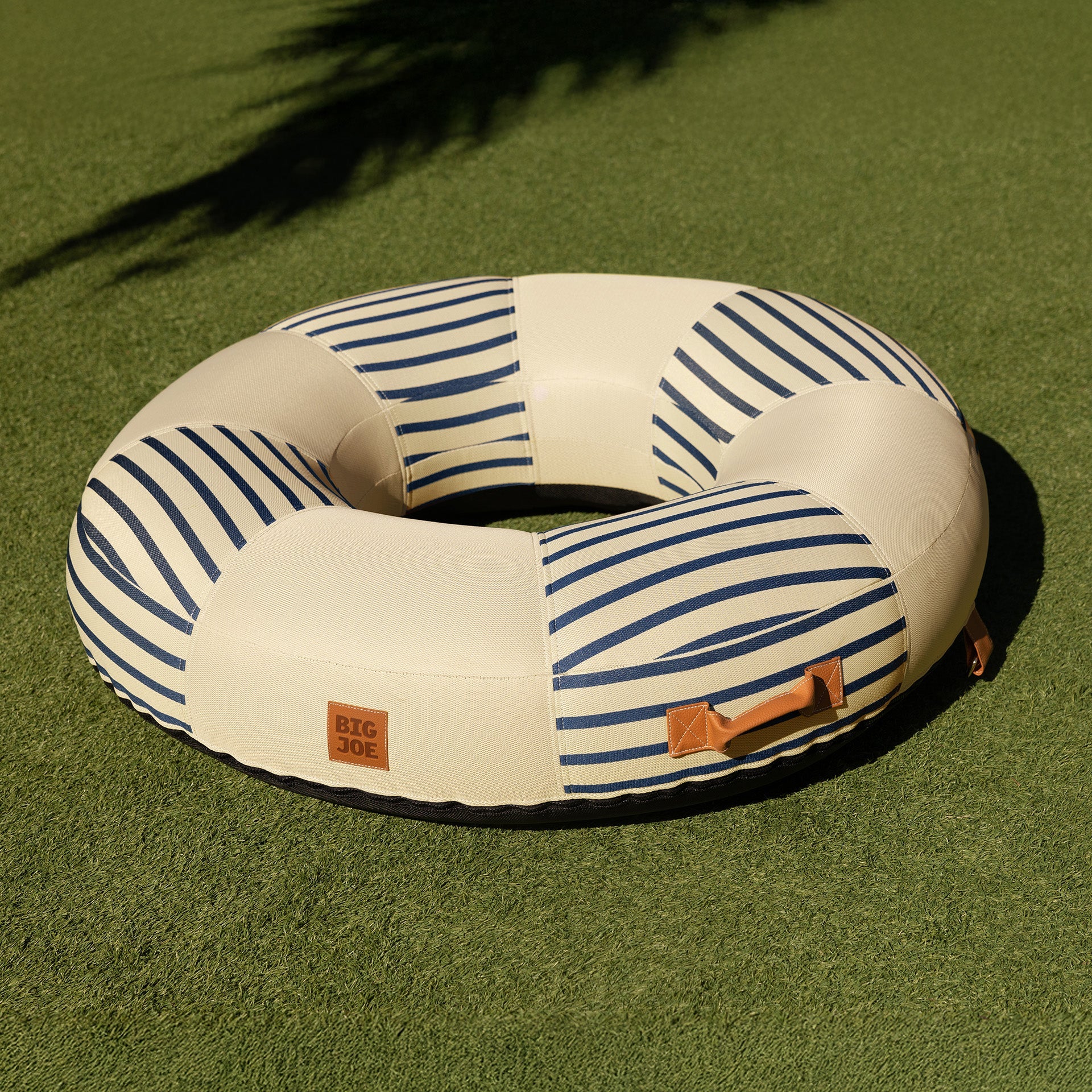 Inflatable ring with striped pattern on a green grass background