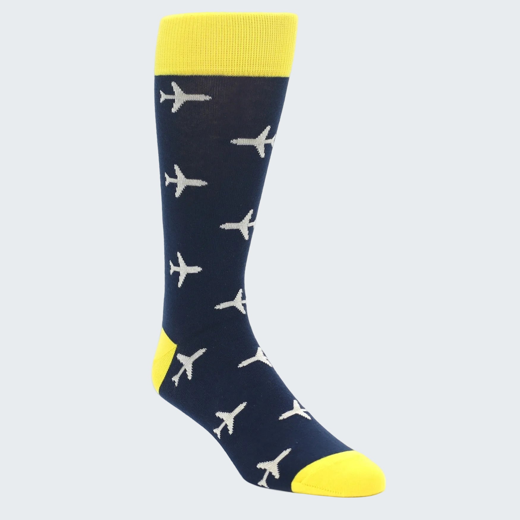 A single crew sock with a navy blue body, bright yellow cuff, heel, and toe, and a repeating pattern of small white airplane silhouettes, shown on a clean white background.