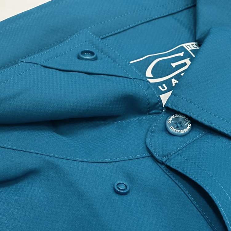 Close-up of a blue shirt with a brand label on a white background